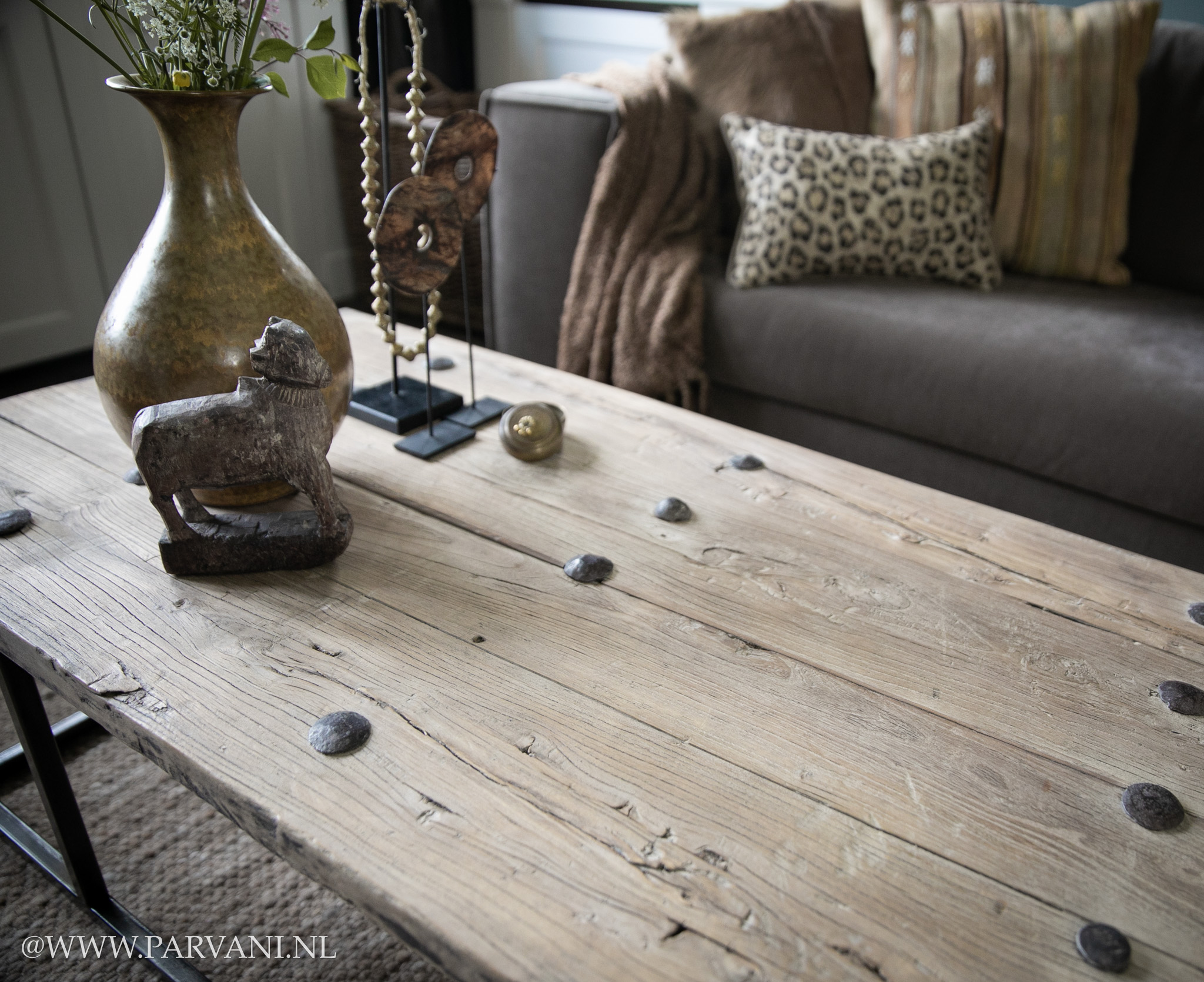 Smalle salontafel met oud houten blad met nagels op metalen onderstel