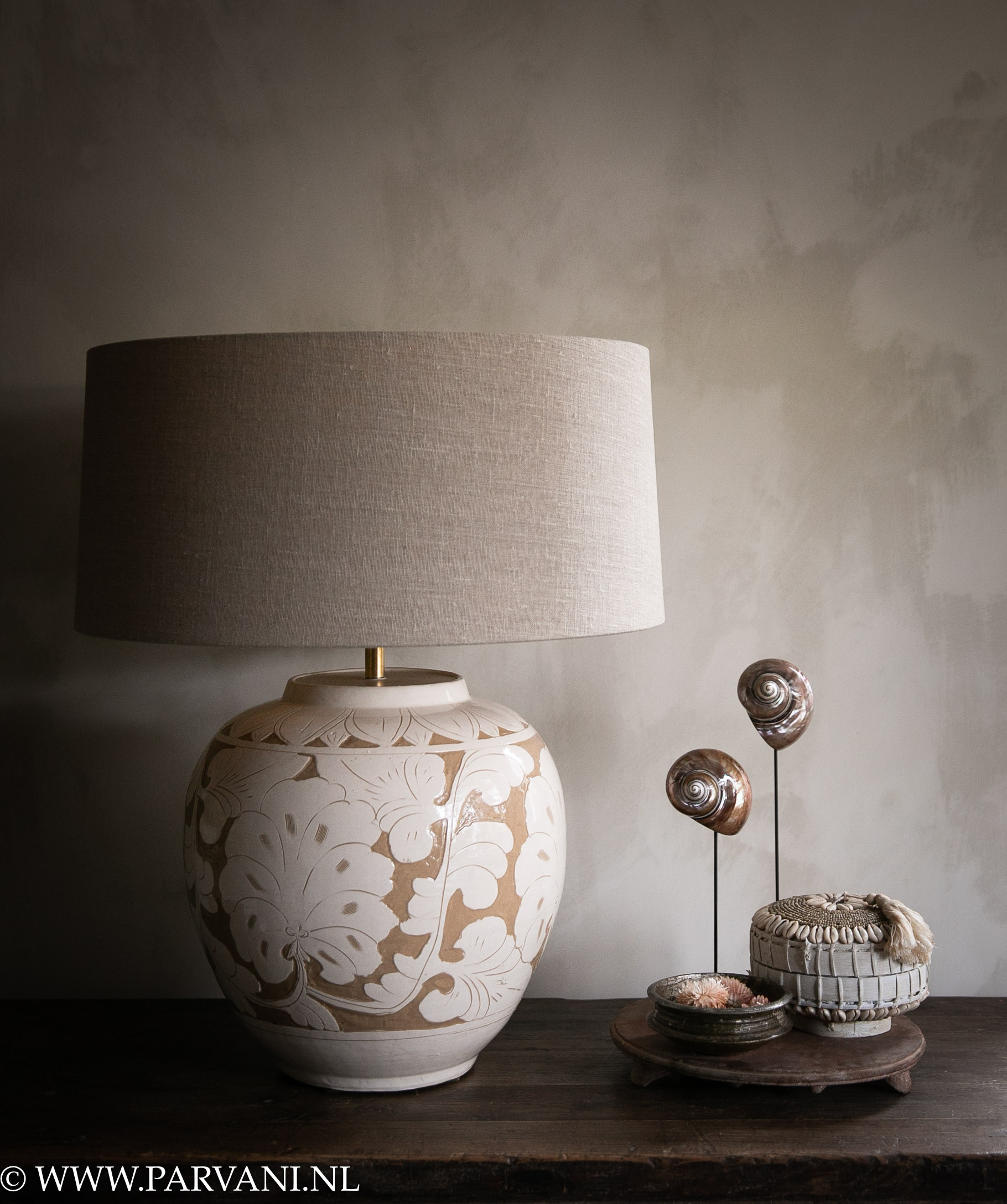 Beige met bruine vaaslamp met bloem patroon en lichte naturel linnen kap, met schelpen, mandje en chapatisteen