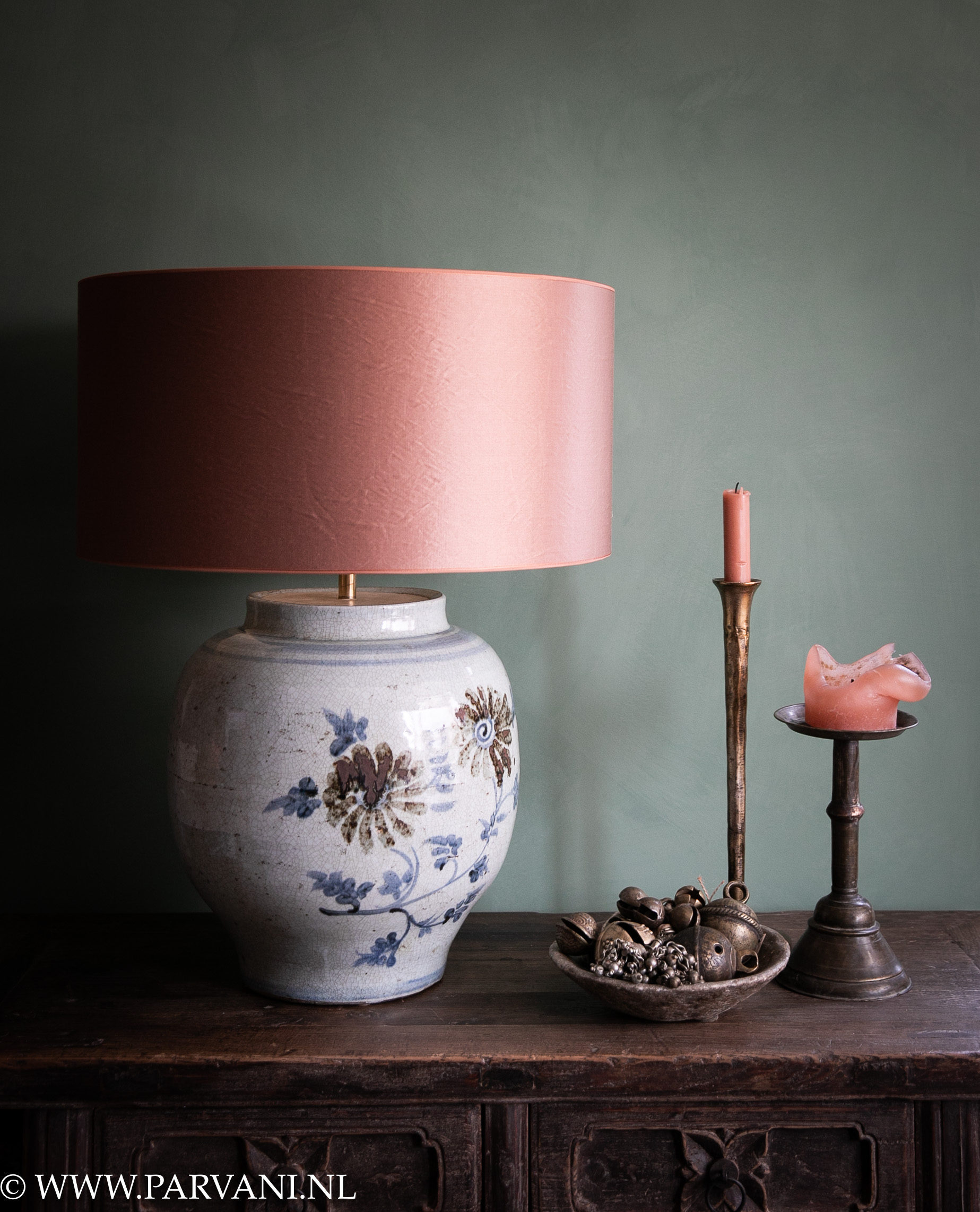 Blauw wit beschilderde tafellamp uit China met roze lampenkap, goudkleurige kandelaars en oude stenen schaal met bronzen bellen