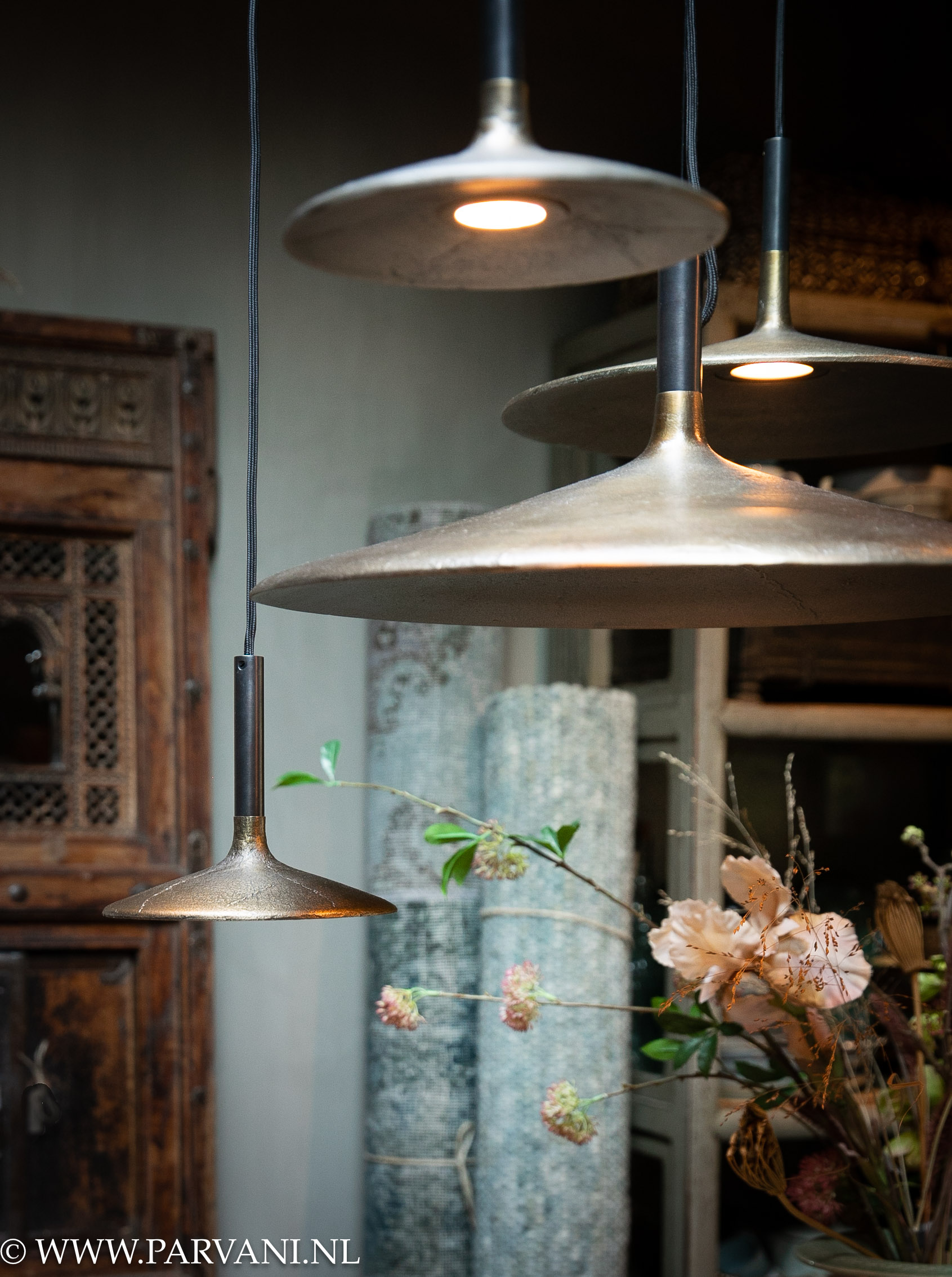 Groepje van meerdere hanglampen Fluente van Frezoli in donker messing kleur boven ronde eettafel