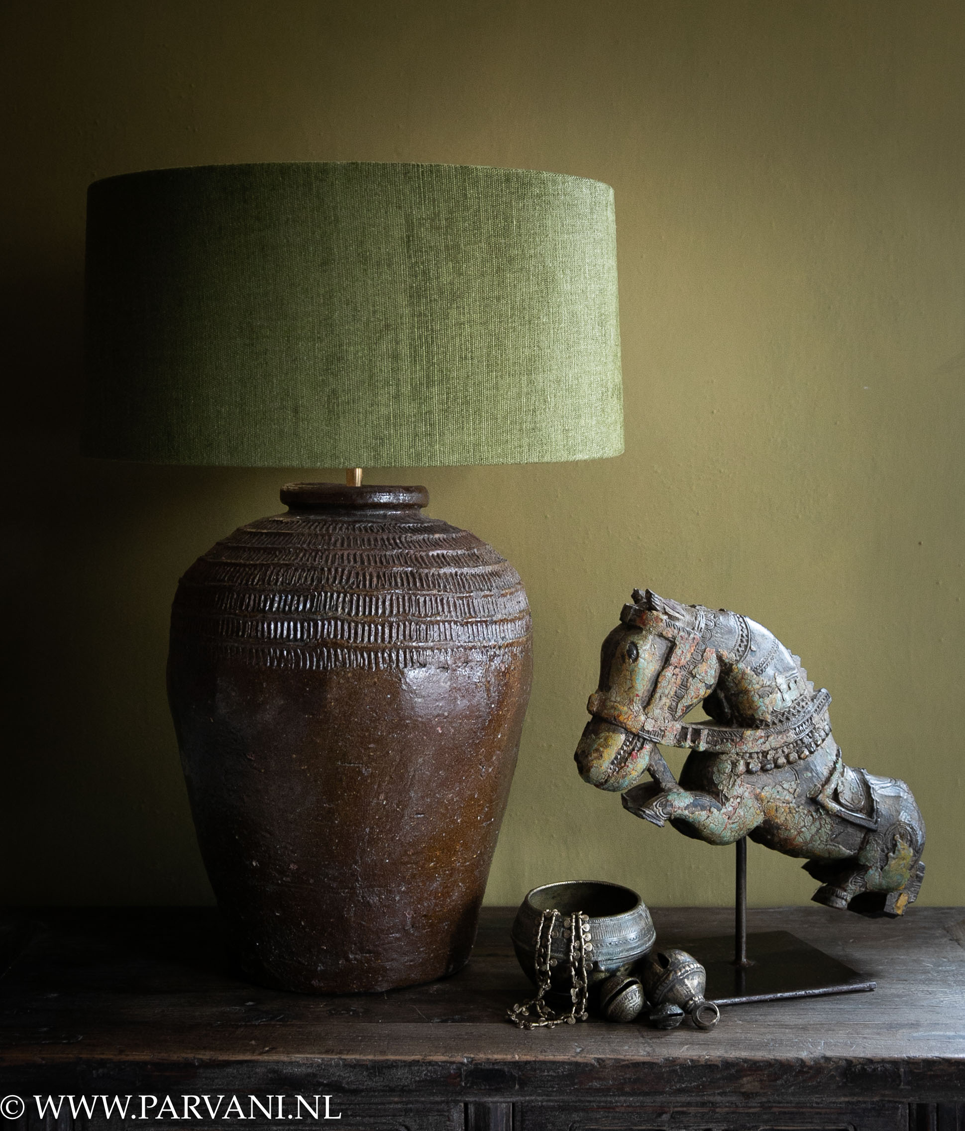 Grote Chinese kruiklamp in warme bruine kleur met mosgroene linnen kap en oud houten paard op standaard en bronzen bellen uit India