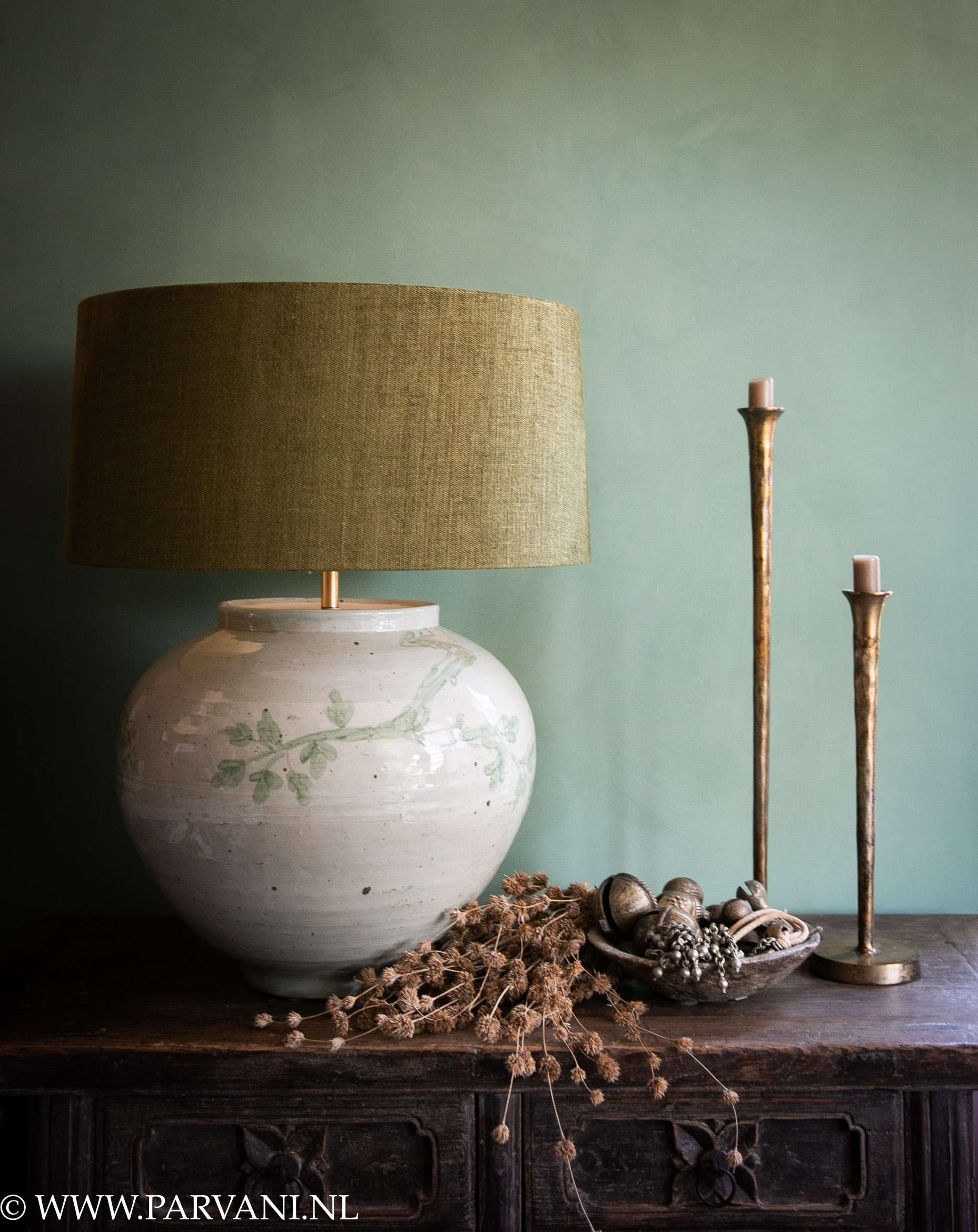 Grote bolle Chinese tafellamp in zacht celadon groen met subtiel handgeschilderd bloem patroon met mosgroene linnen kap en goudkleurige kandelaars en oude bronzen bellen