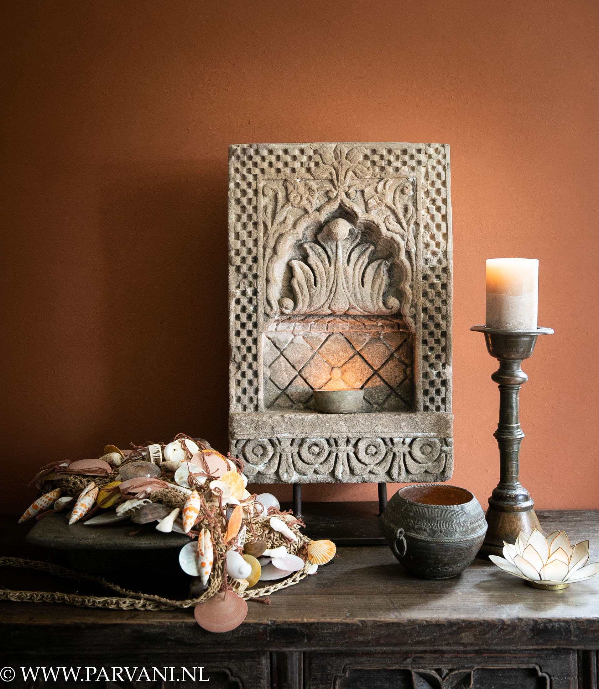 Grote unieke Indiase tempelsteen op standaard met oude koperen kandelaar en rijstmaat met schelpentasje op ayurvede steen