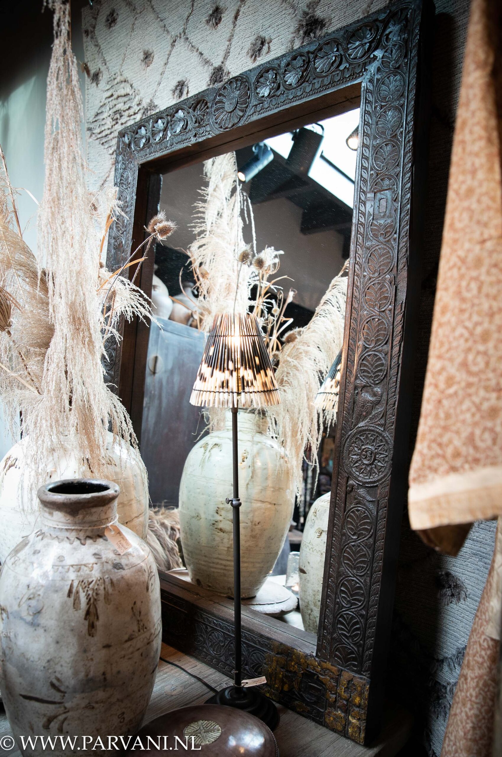 Grote unieke houten spiegel met donkere lijst en prachtig snijwerk uit Zuid India