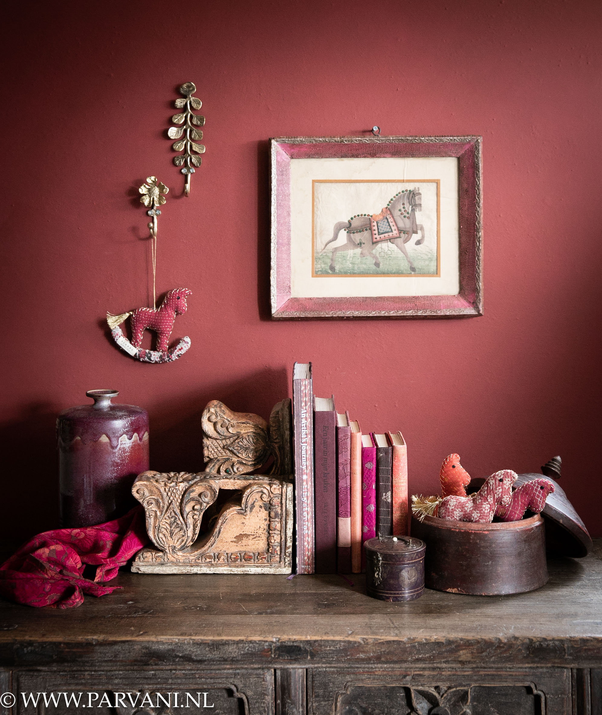 Messing ophang haken met oud schilderijtje en ornament boekensteunen uit India met paardjes van Sissel Edelbo