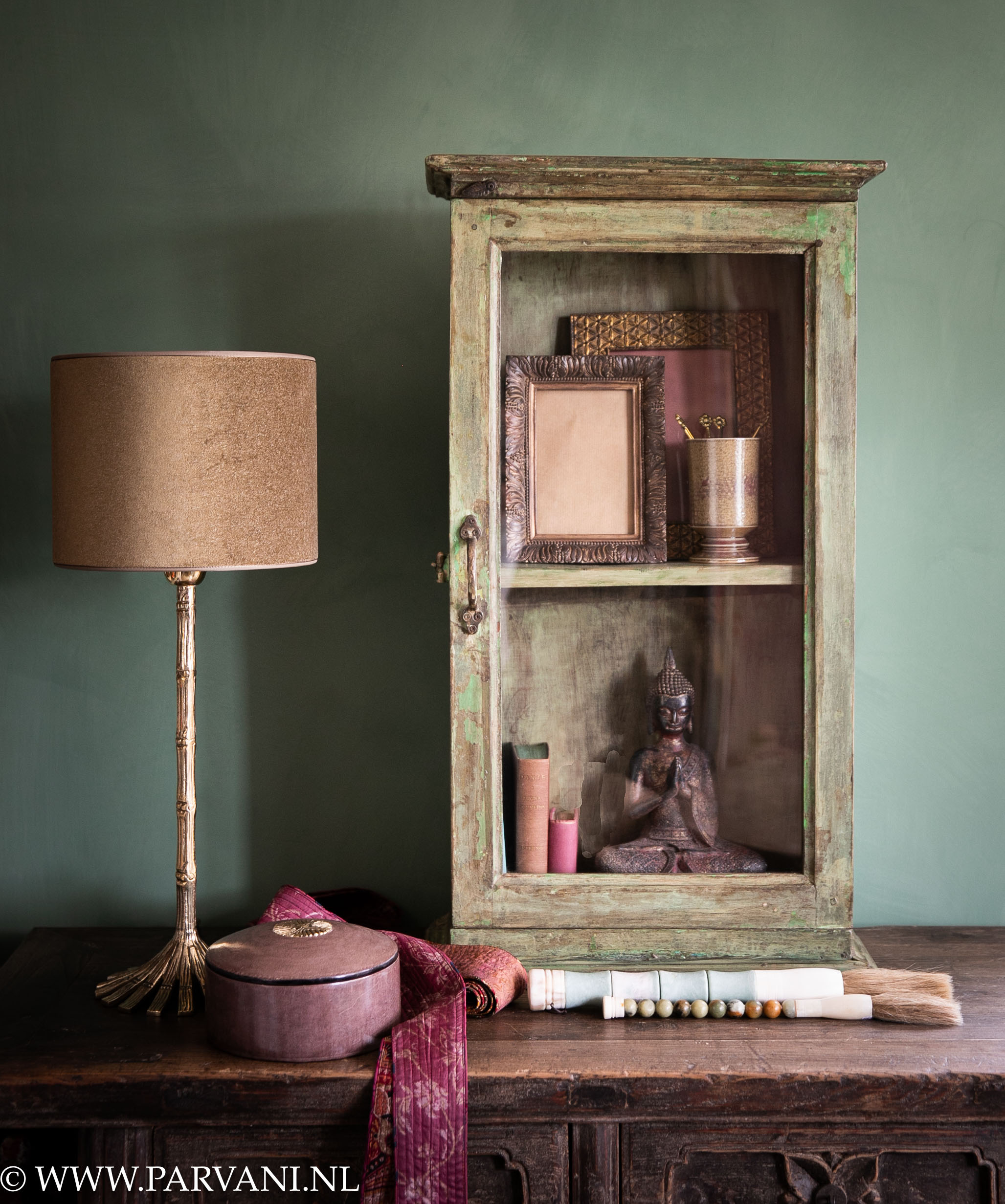 Oud houten glaskastje hangkastje vitrine uit India in groene kleur met brass tafellamp met bronskleur velvet kap en accessoires