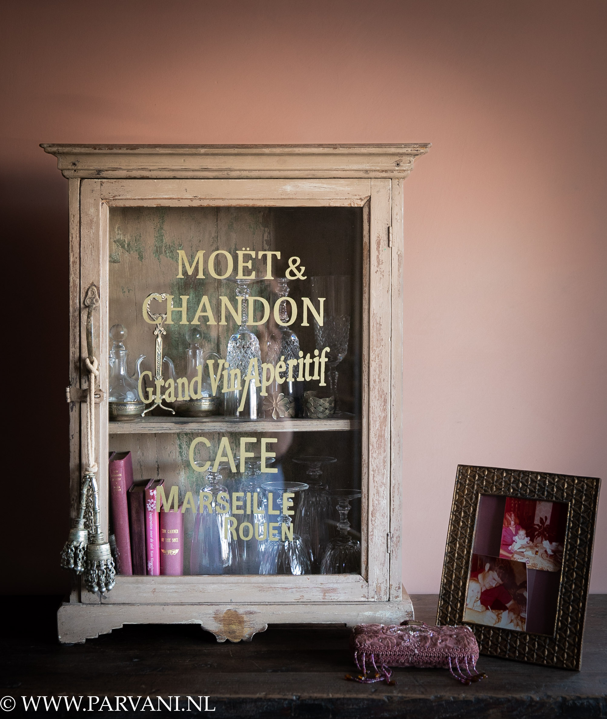 Oud houten vitrinekastje hangkastje met naturel roze kleur en glas met goudkleurige tekst_