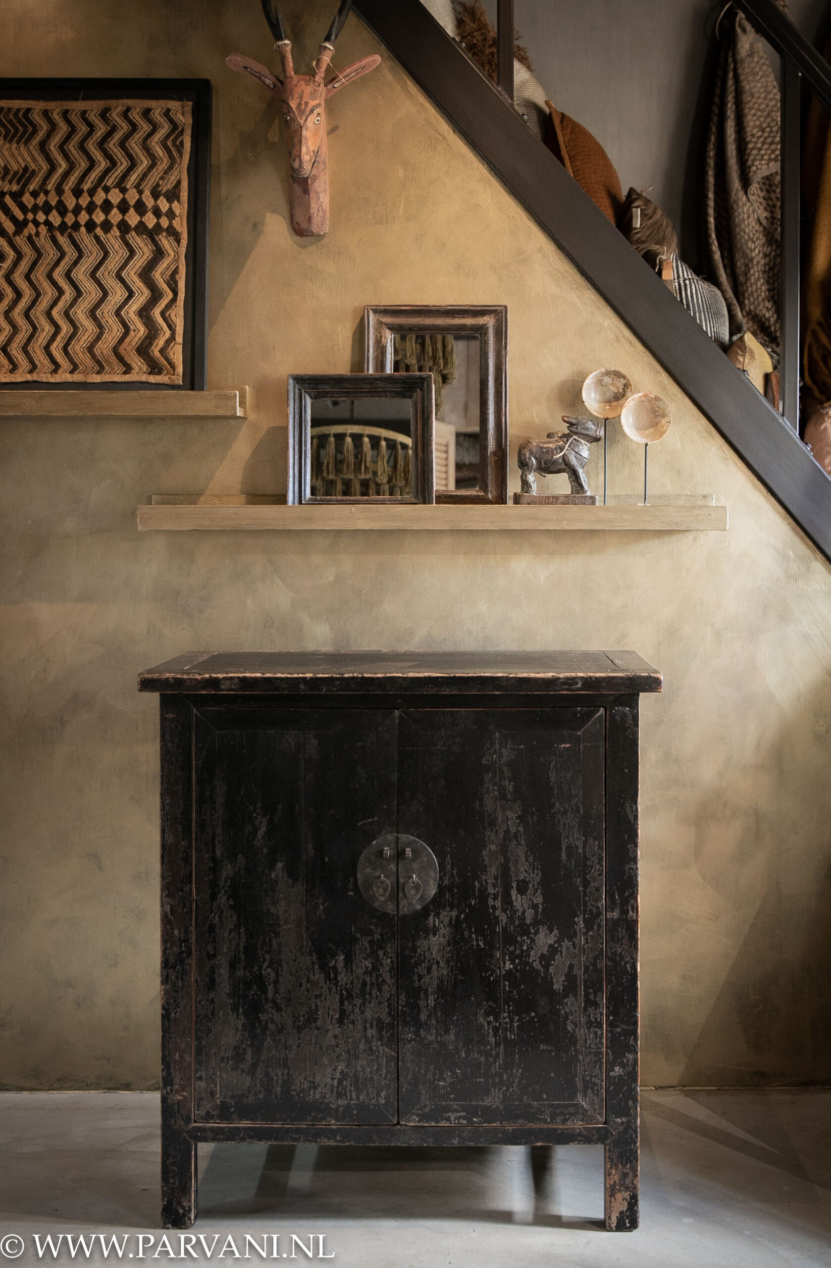 Oud uniek zwart Chinees 2 deurs kastje met messing beslag tegen goudkleurige metallicverf wand