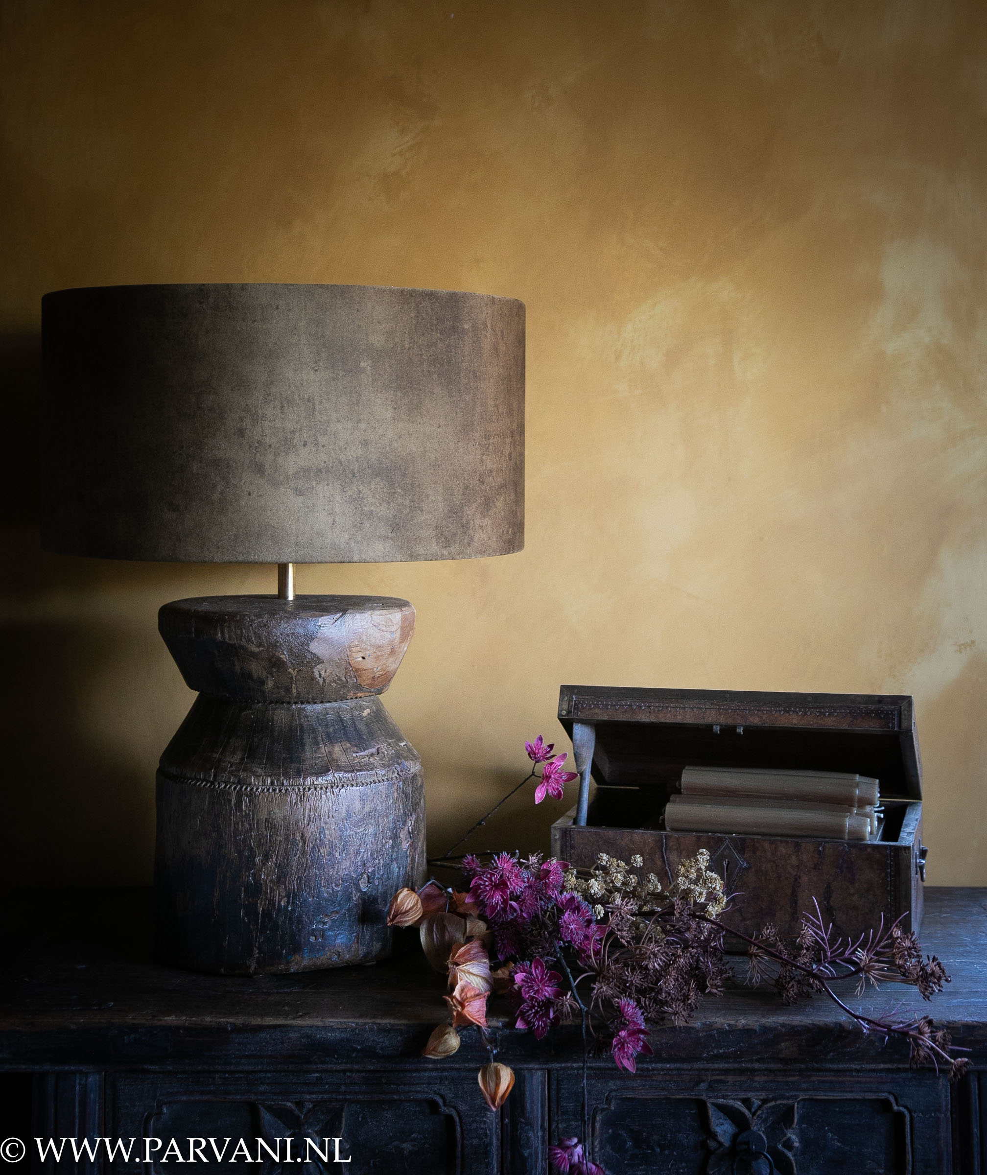 Oude houten tafellamp uit India met oker bruine velvet kap en oud houten kistje met zijden bloemen