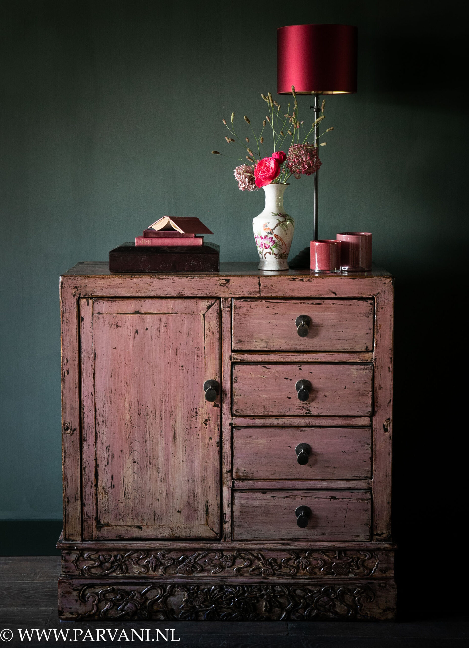 Roze kastje Chinees lakwerk met deurtje en lades met tafellamp met fel roze kap, porseleinen vaasje en windlichten