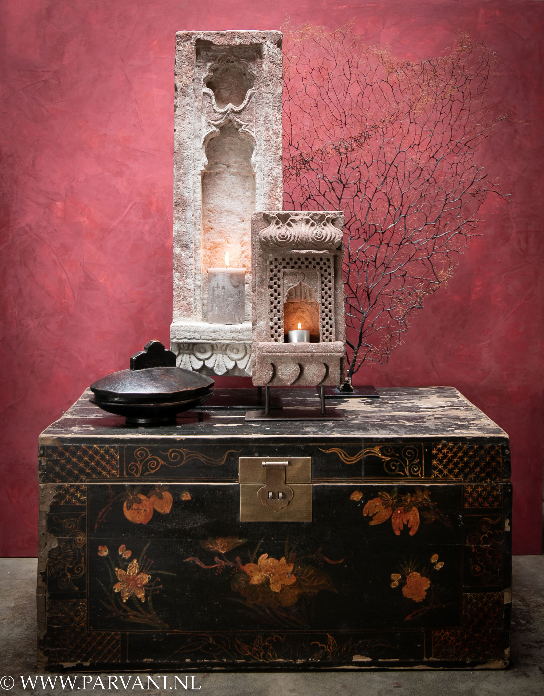 Indiase tempelstenen huis altaar met kaarsje op oude zwarte houten kist met beschildering uit China