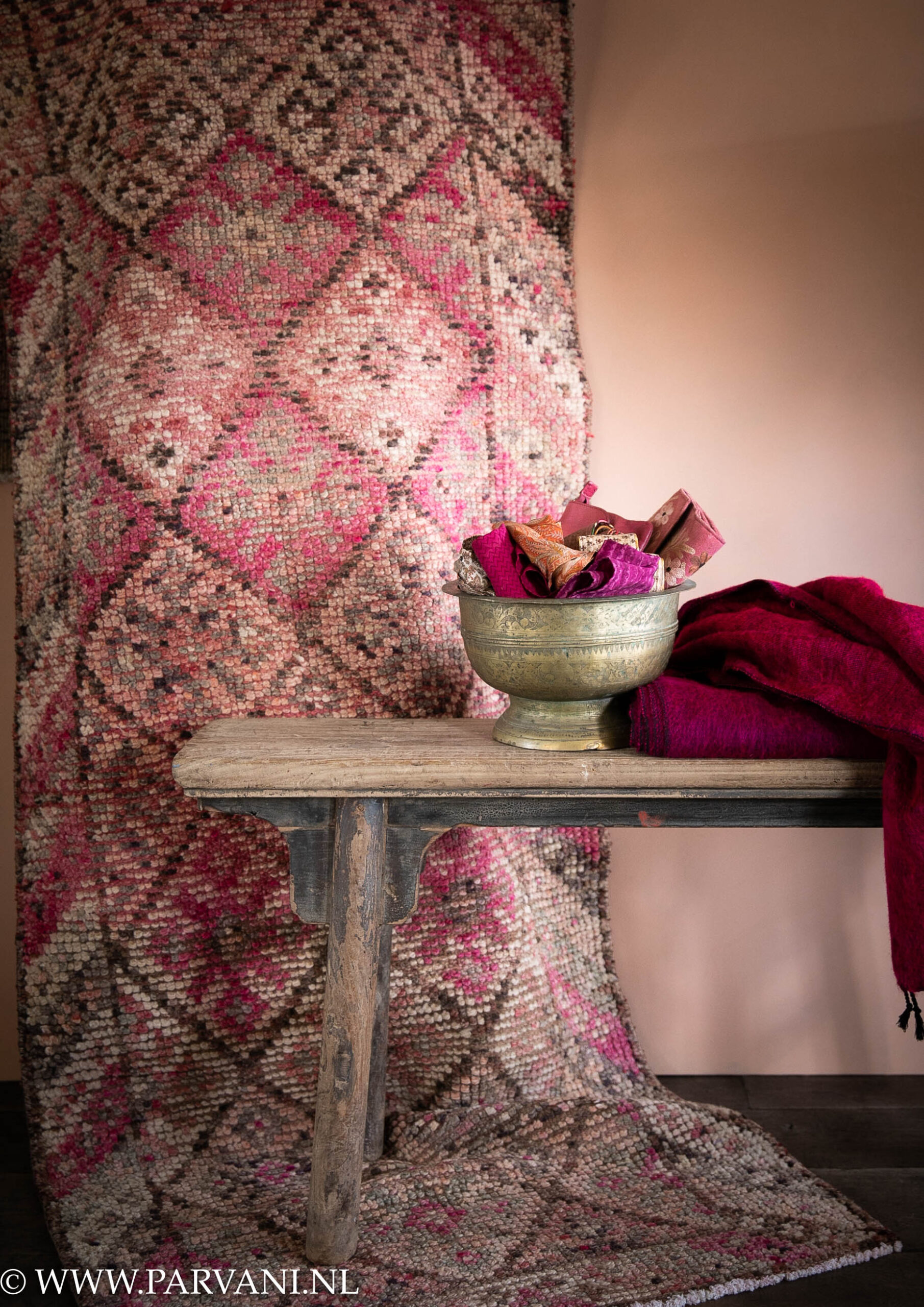 Kleurrijke roze vintage loper kelim runner met oud houten bankje en messing schaal