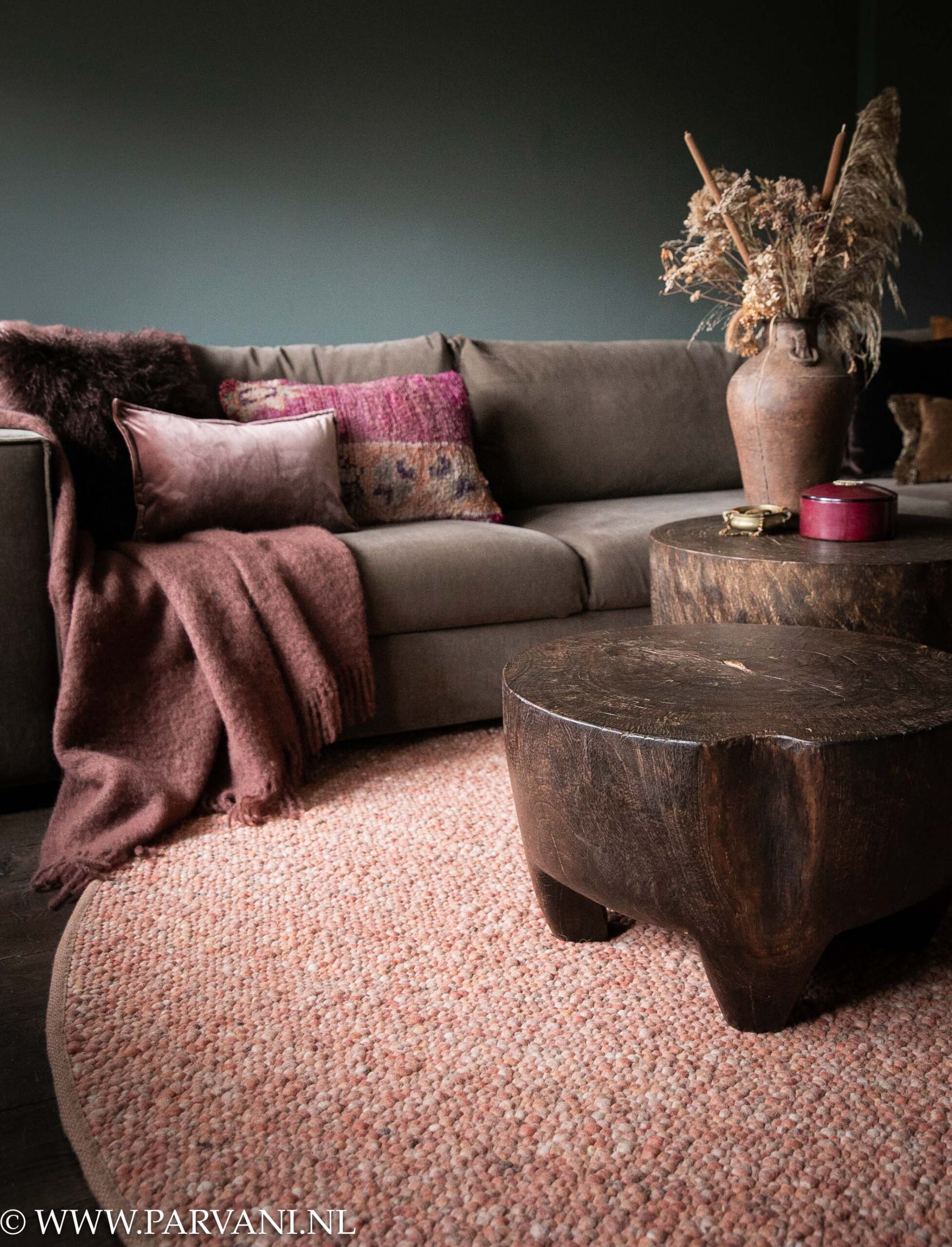 Rond wollen tapijt handgeknoopt in warme terra roze kleur met grove onregelmatige bolletjes structuur