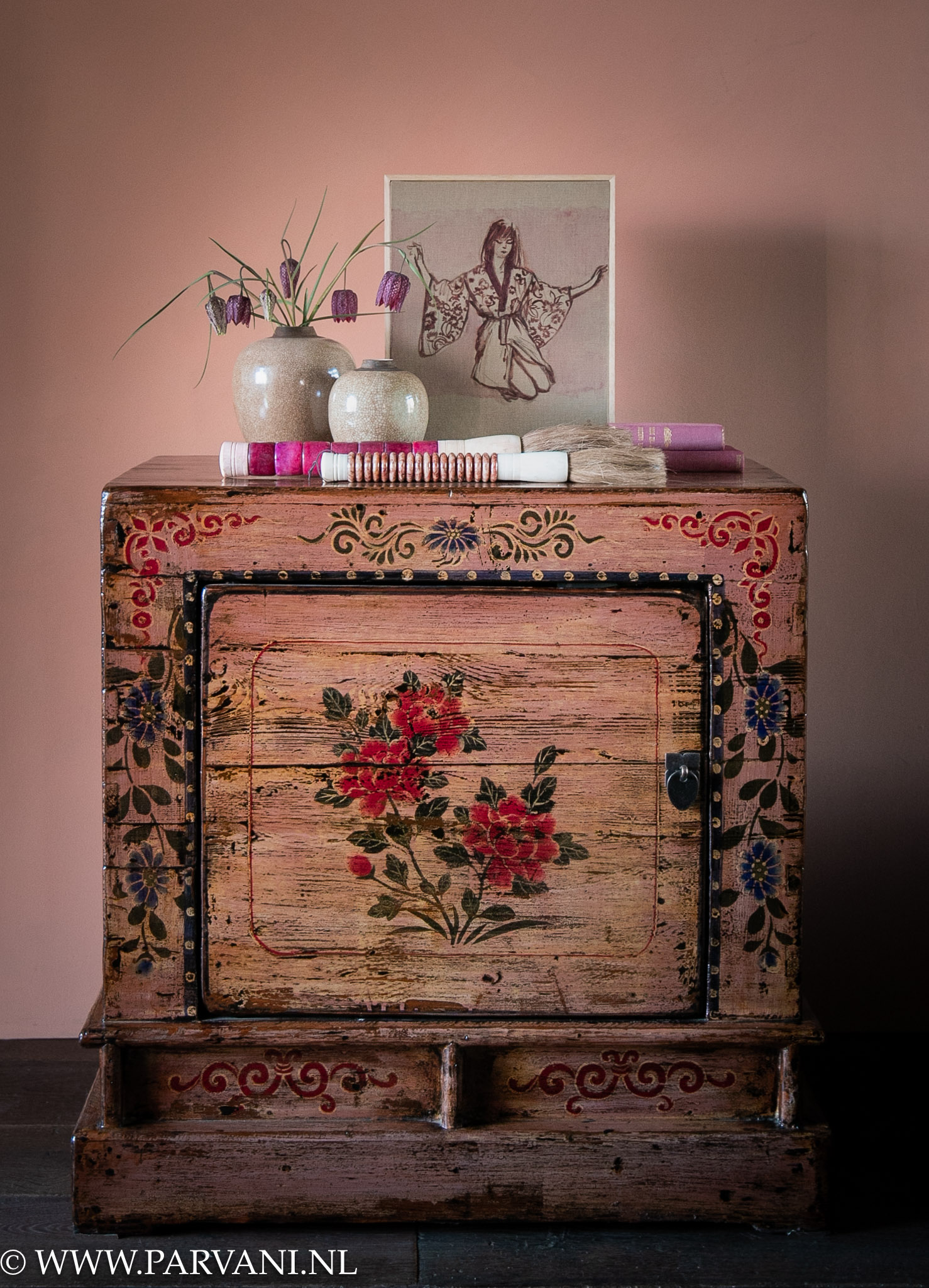 Set kleurrijke roze houten nachtkastjes met beschilderd patroon met bloemen en beige vaasjes, klein schilderijtje en Chinese kwasten
