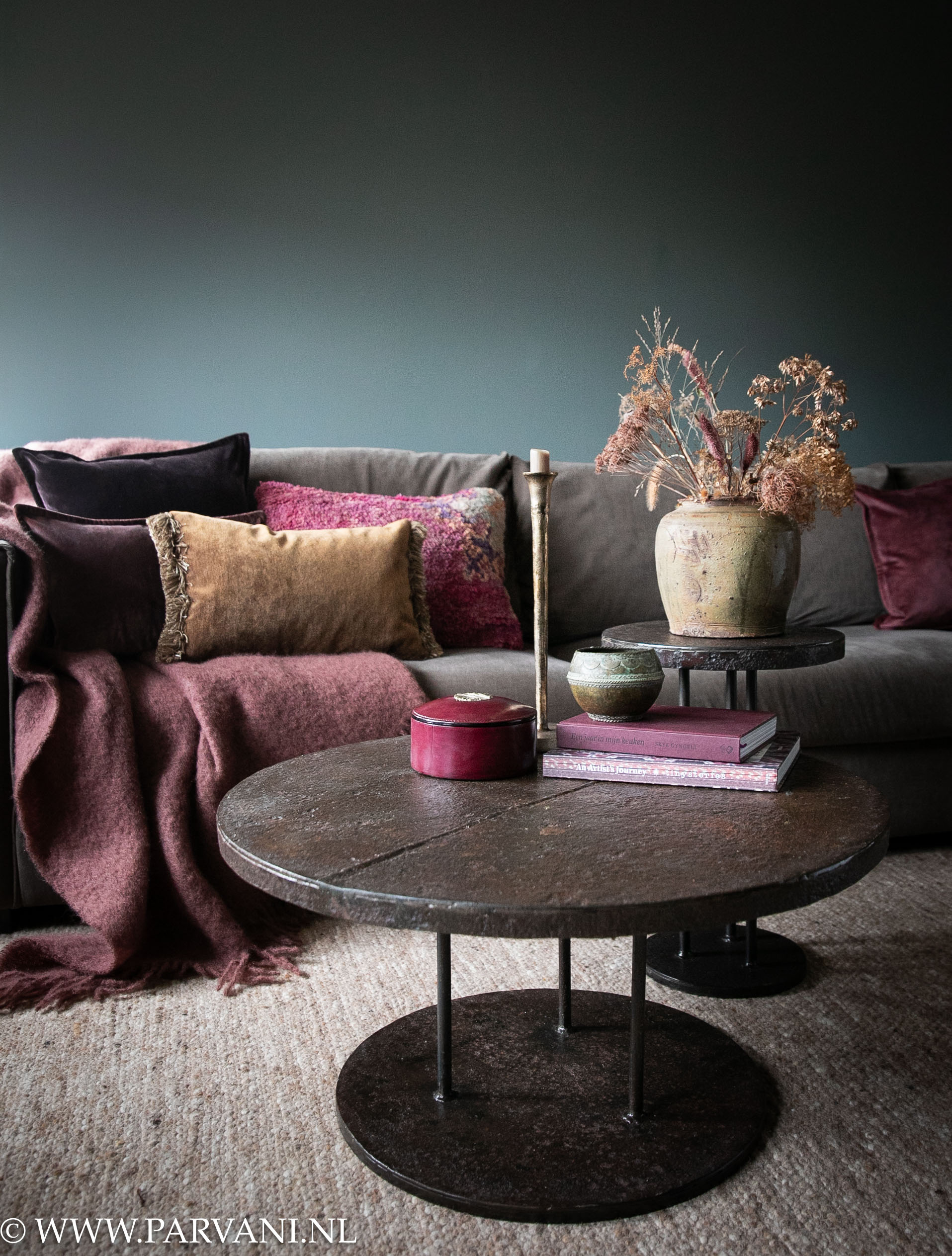 Stoere ronde ijzeren salontafel met robuust blad en roestbruine kleur patina met kleine hogere bijzettafel