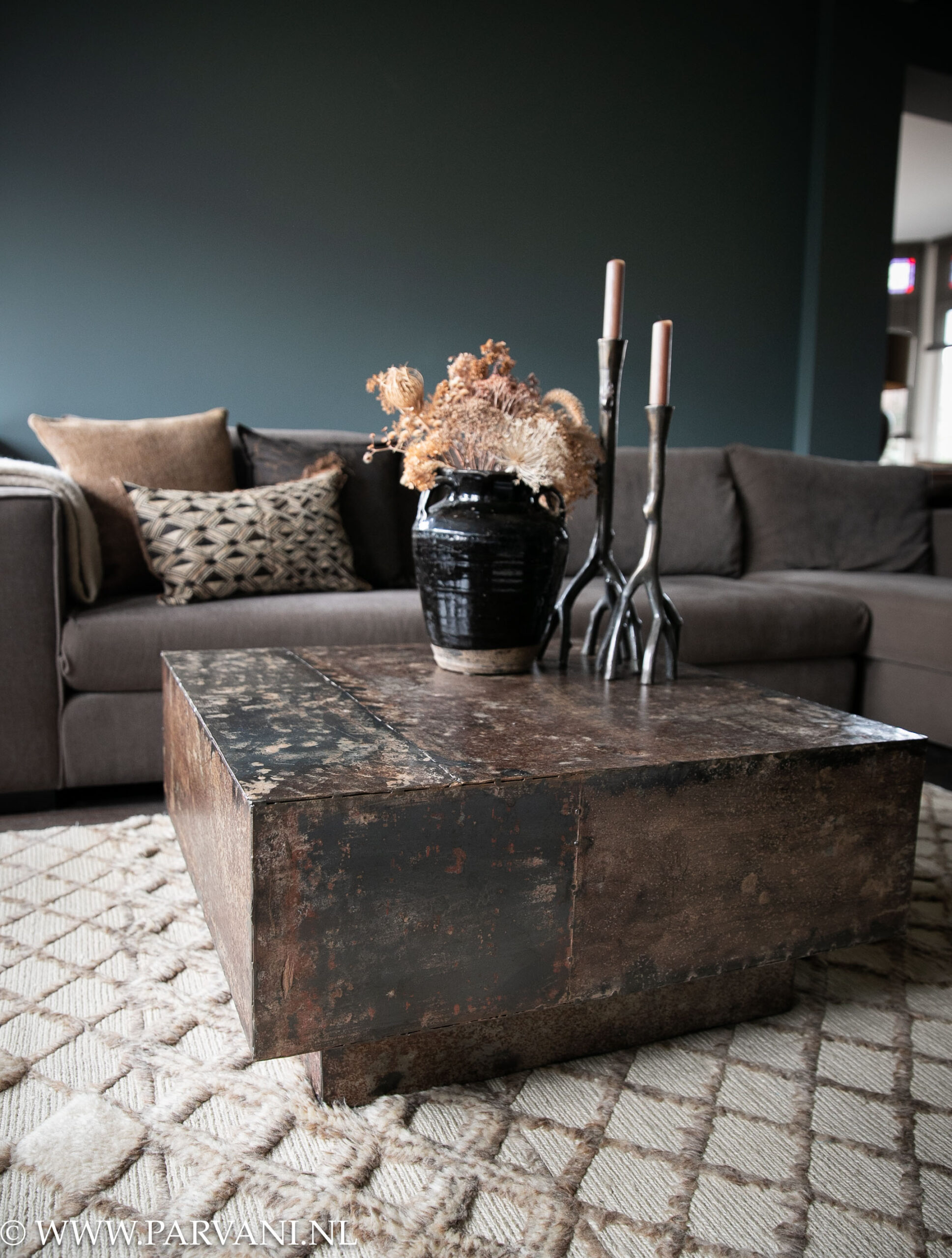 Vierkante vintage metalen salontafel donkerbruin kubus op beige berber tapijt met grafisch patroon