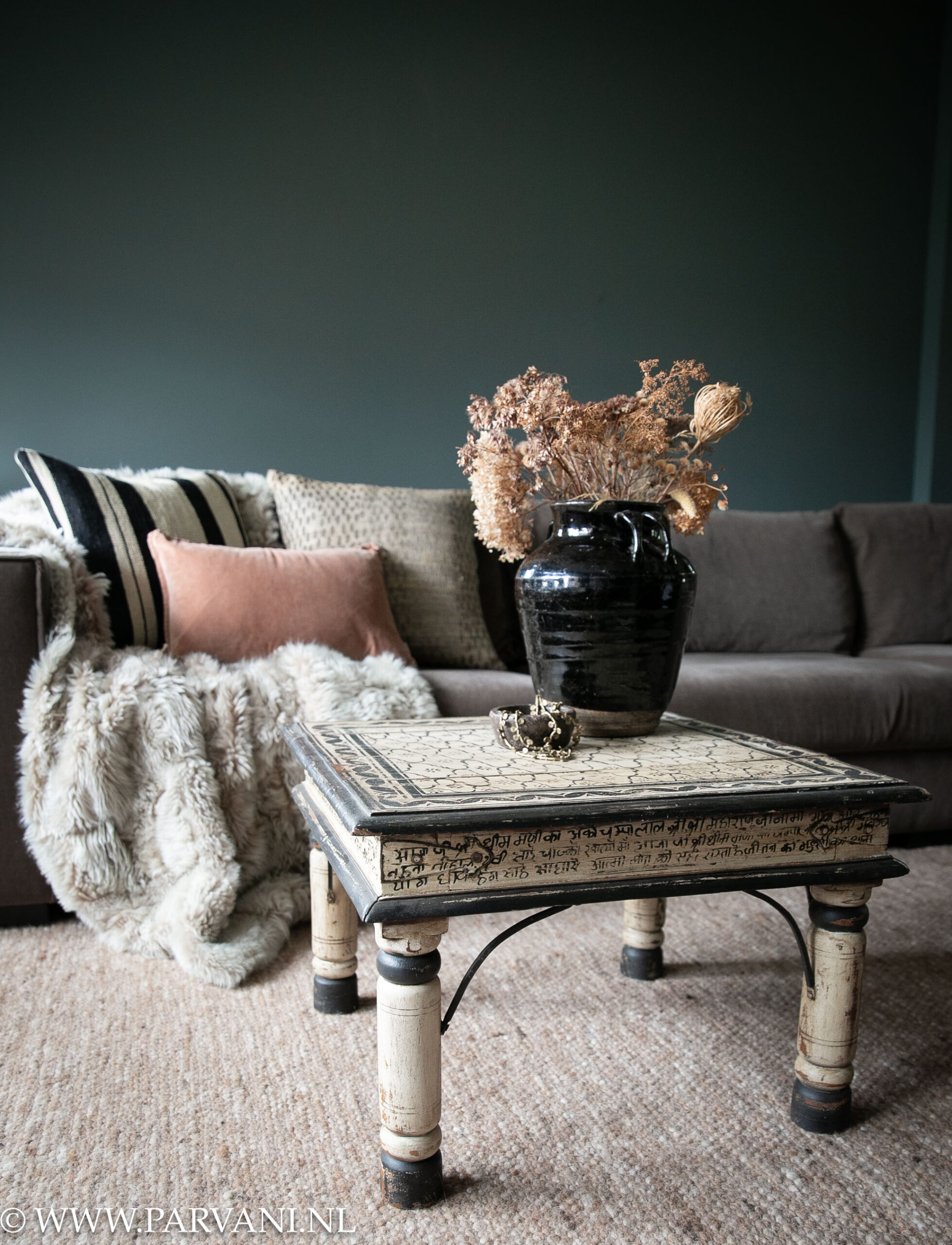 Vierkante zwart wit beschilderde bijzettafel salontafel uit India met sierkussens, plaid en wollen vloerkleed in oud roze kleur