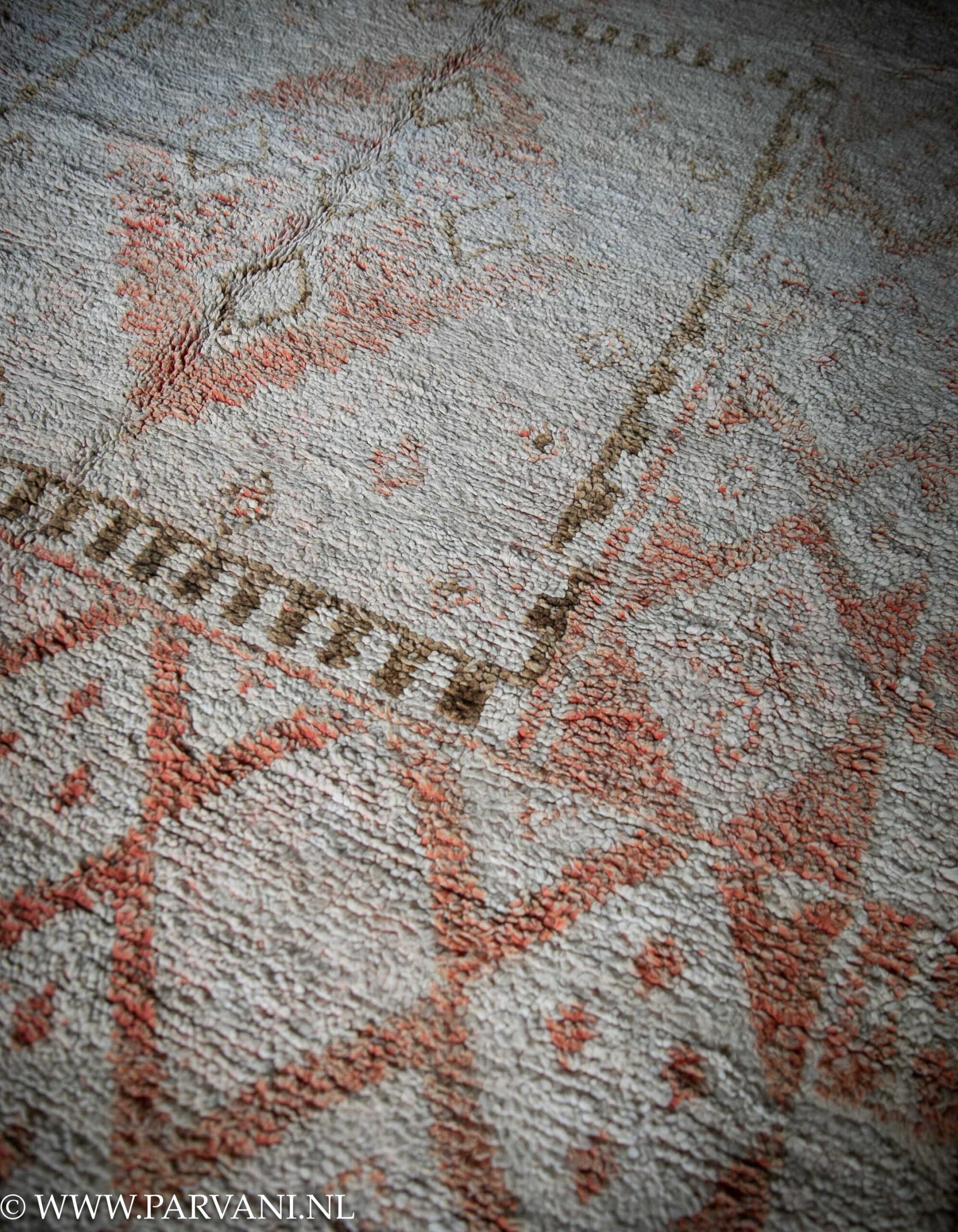 Wollen berber tapijt in lichte beige basiskleur met patroon in warme terra oranje en bruin caramel tinten