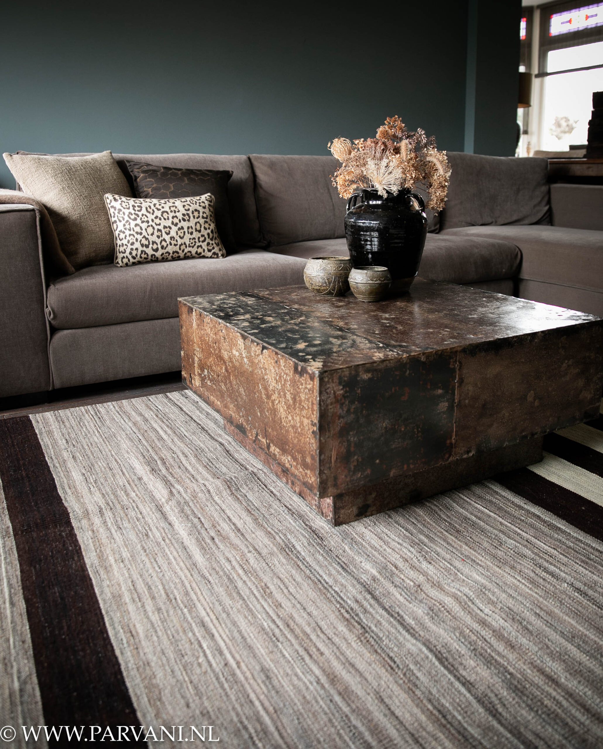 Wollen kelim tapijt met gestreept patroon in beige, bruin, zwarte kleuren met vierkante metalen salontafel