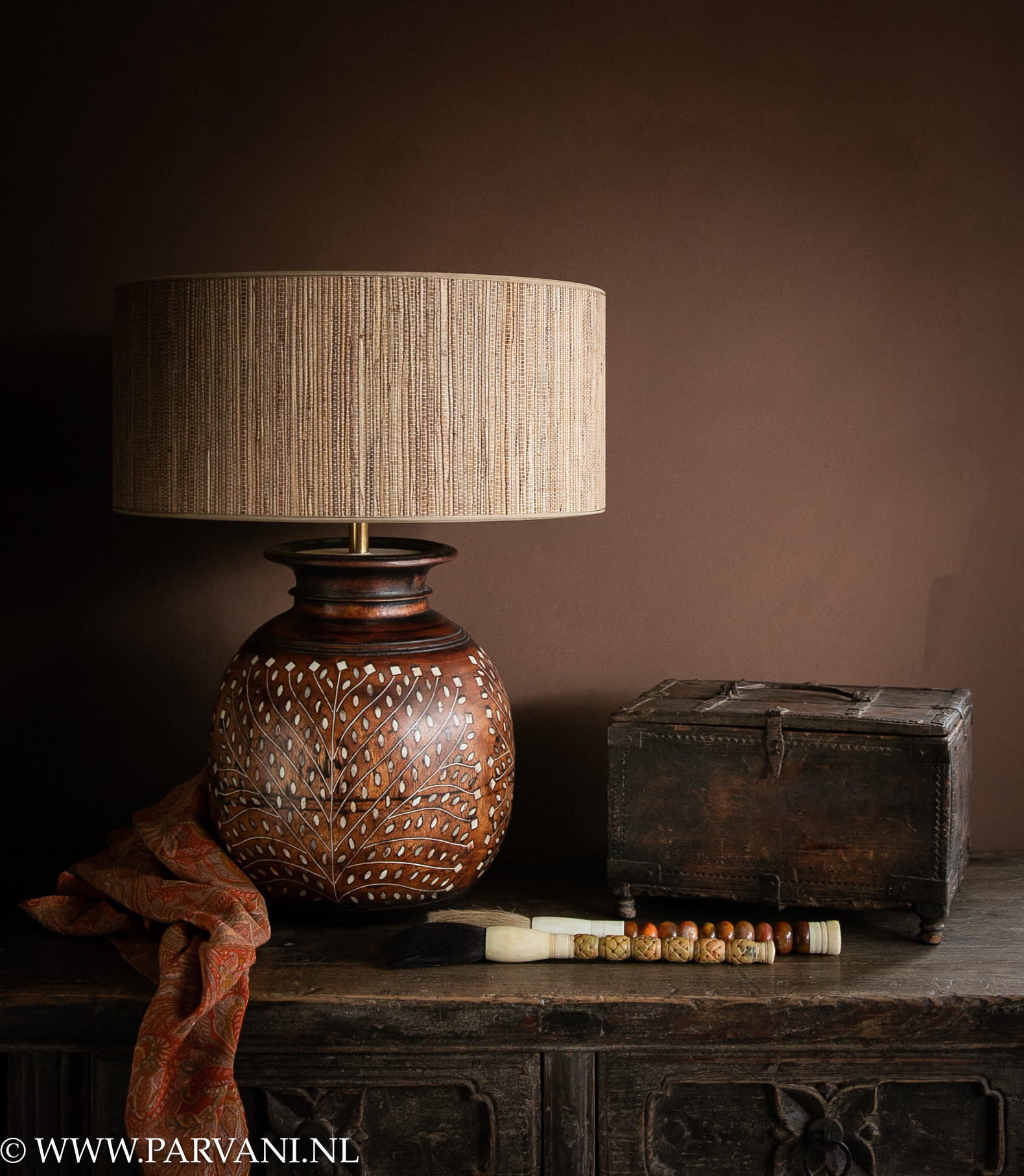Houten tafellamp met naturel raffia kap en oud Indiaas kistje en accessoires in warme kleuren