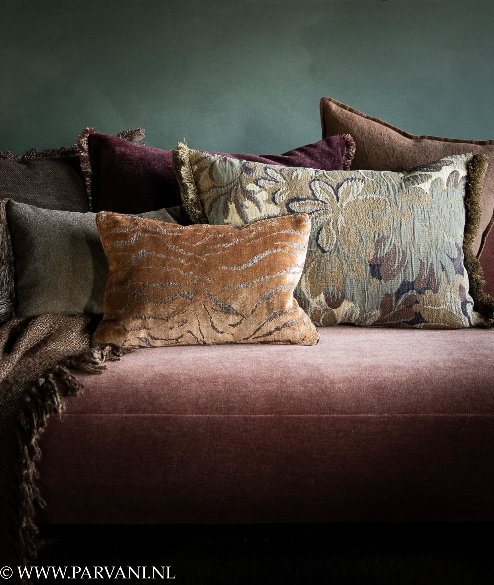 Luxe kussens en plaid in warme oker bruin groen en burgundy kleuren met patroon en franjes