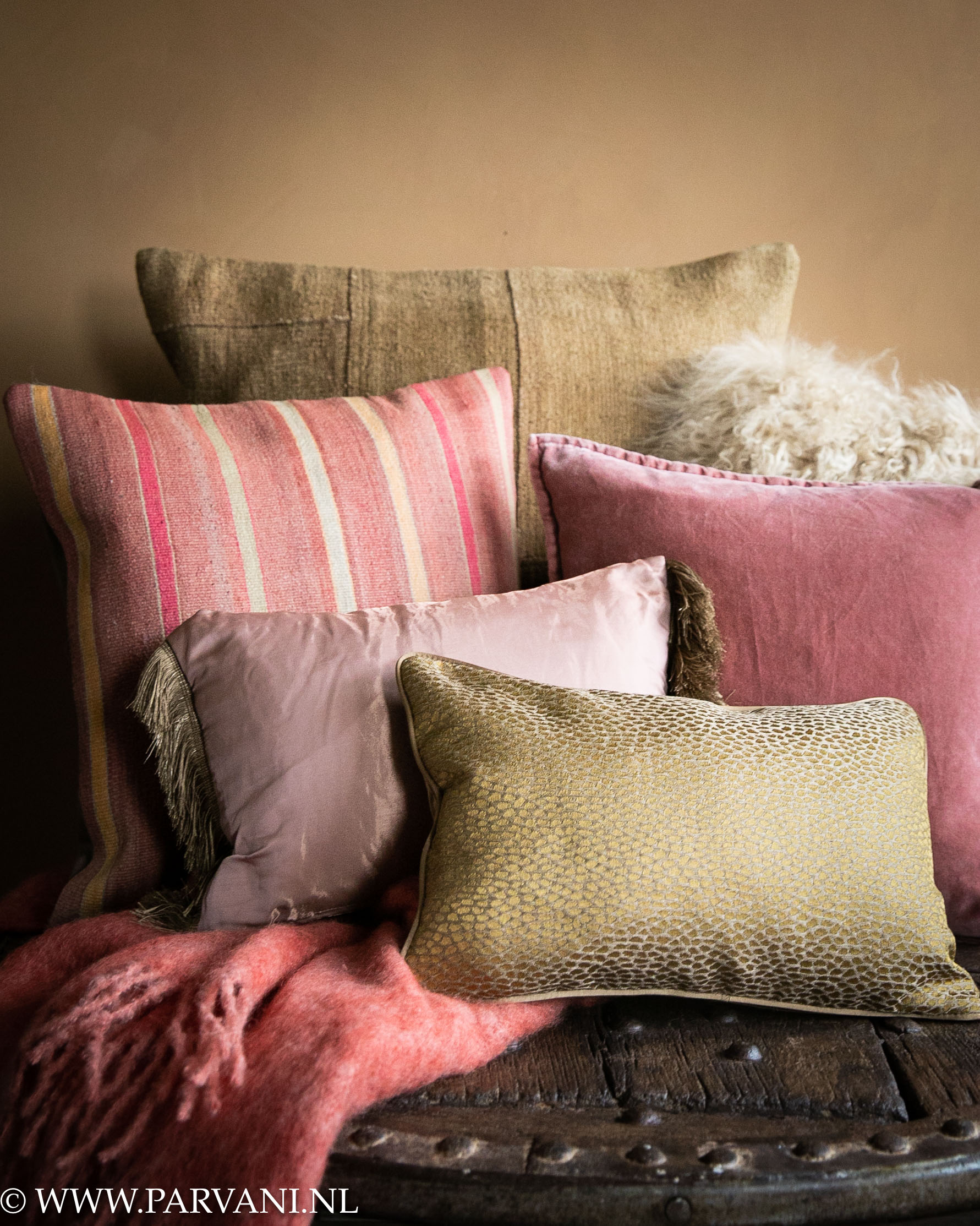 Mix kleurrijke kussens en plaid in roze en oker curry goudkleuren