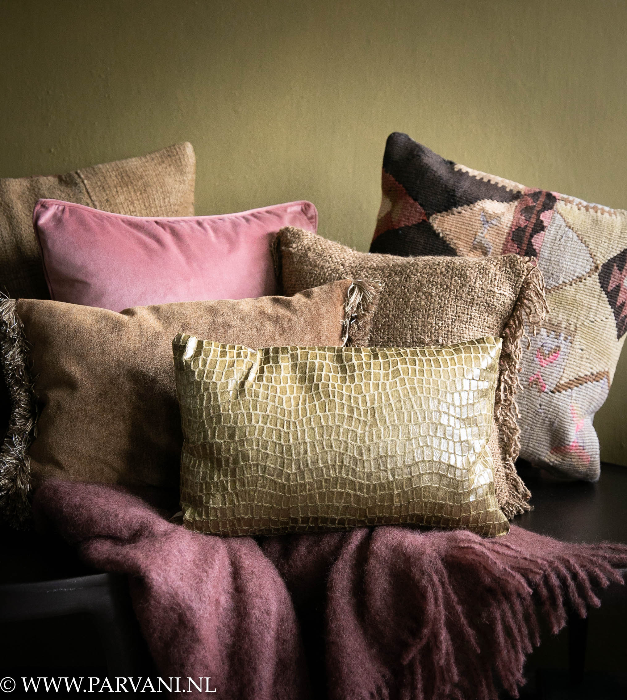 Mix van mohair wollen plaid met sierkussens met kelim, hemp, velvet en croco patroon in warme curry oker bruin met roze kleuren