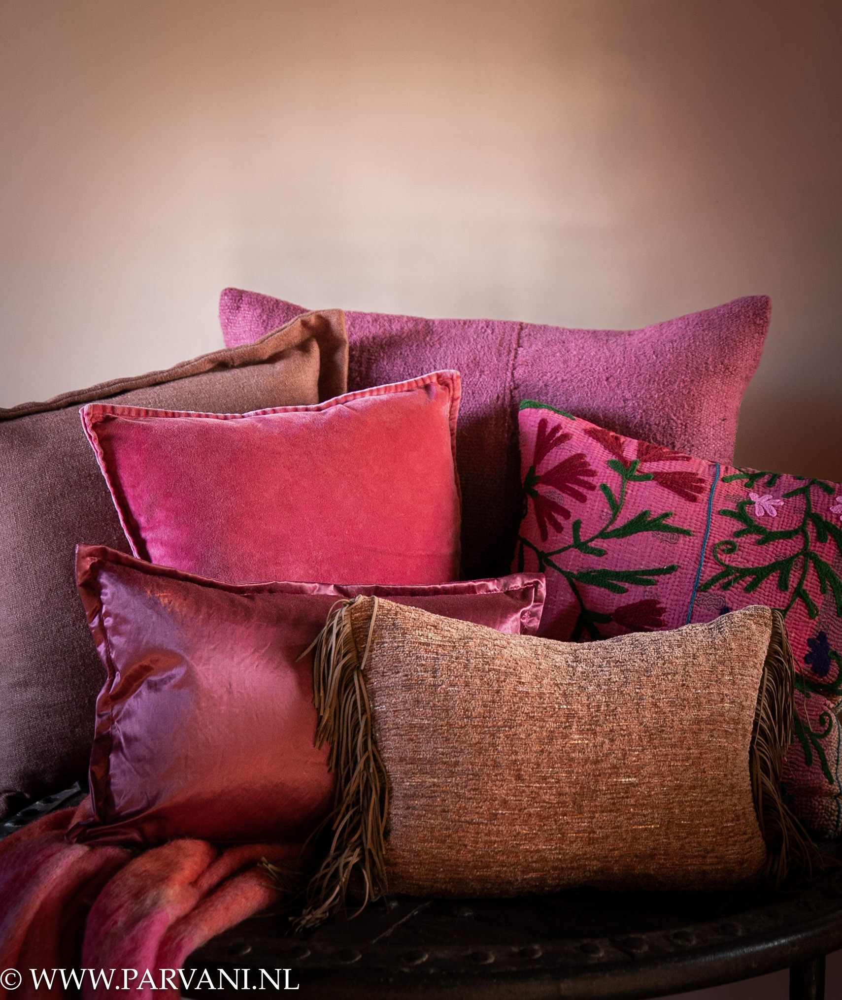 Set kleurrijke kussens en plaid in fel roze, cyclaam, burgundy tinten