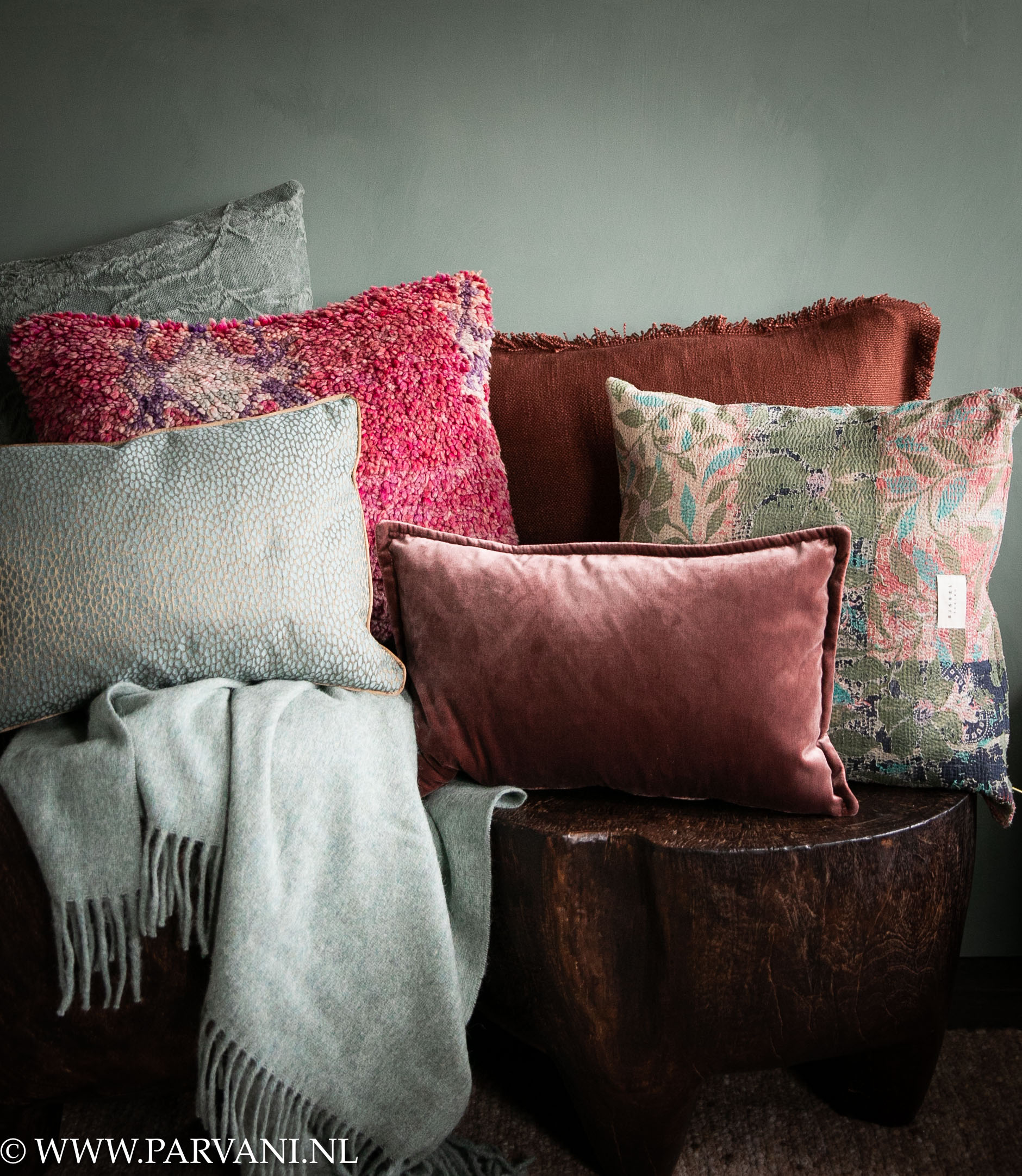Set kleurrijke kussens en wollen plaid in warme burgundy rood roze en zacht turquoise groene kleuren