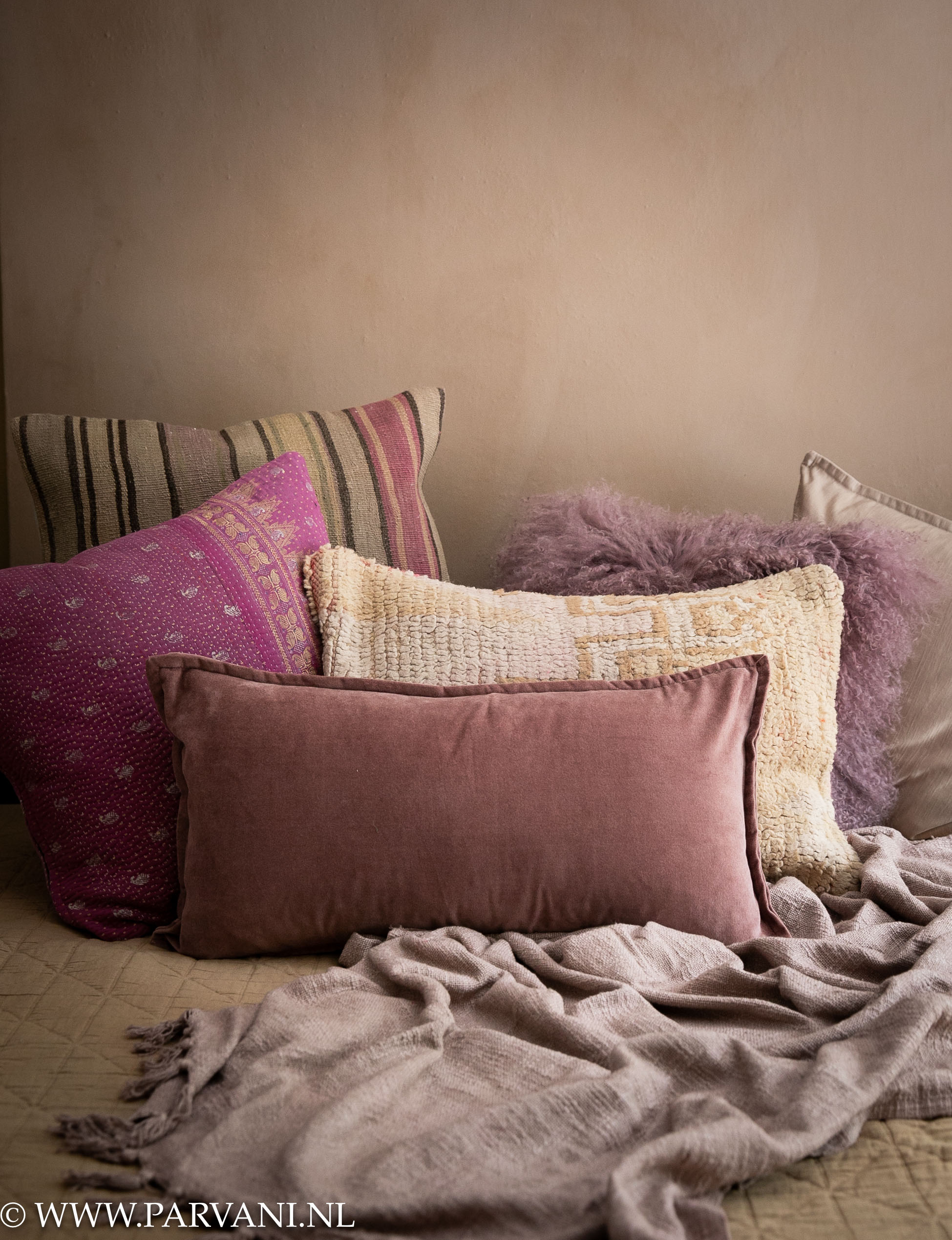 Mix sierkussens met kelim, vacht en velvet in warme naturel, camel en paars lila tinten met bedsprei en linnen plaid