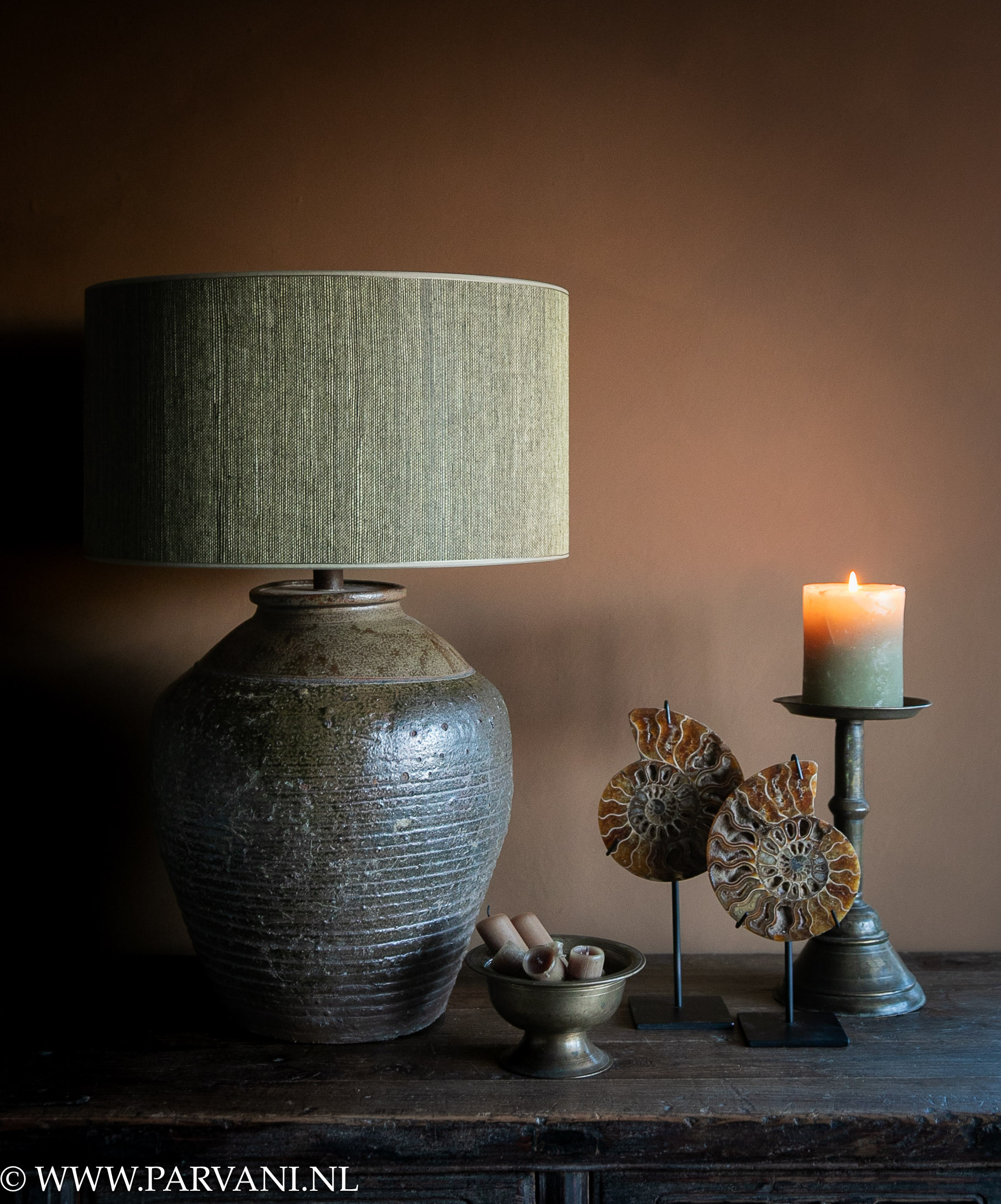 Groen bruine tafellamp met olijfgroene kap, kandelaar en set bruine ammonieten op standaard