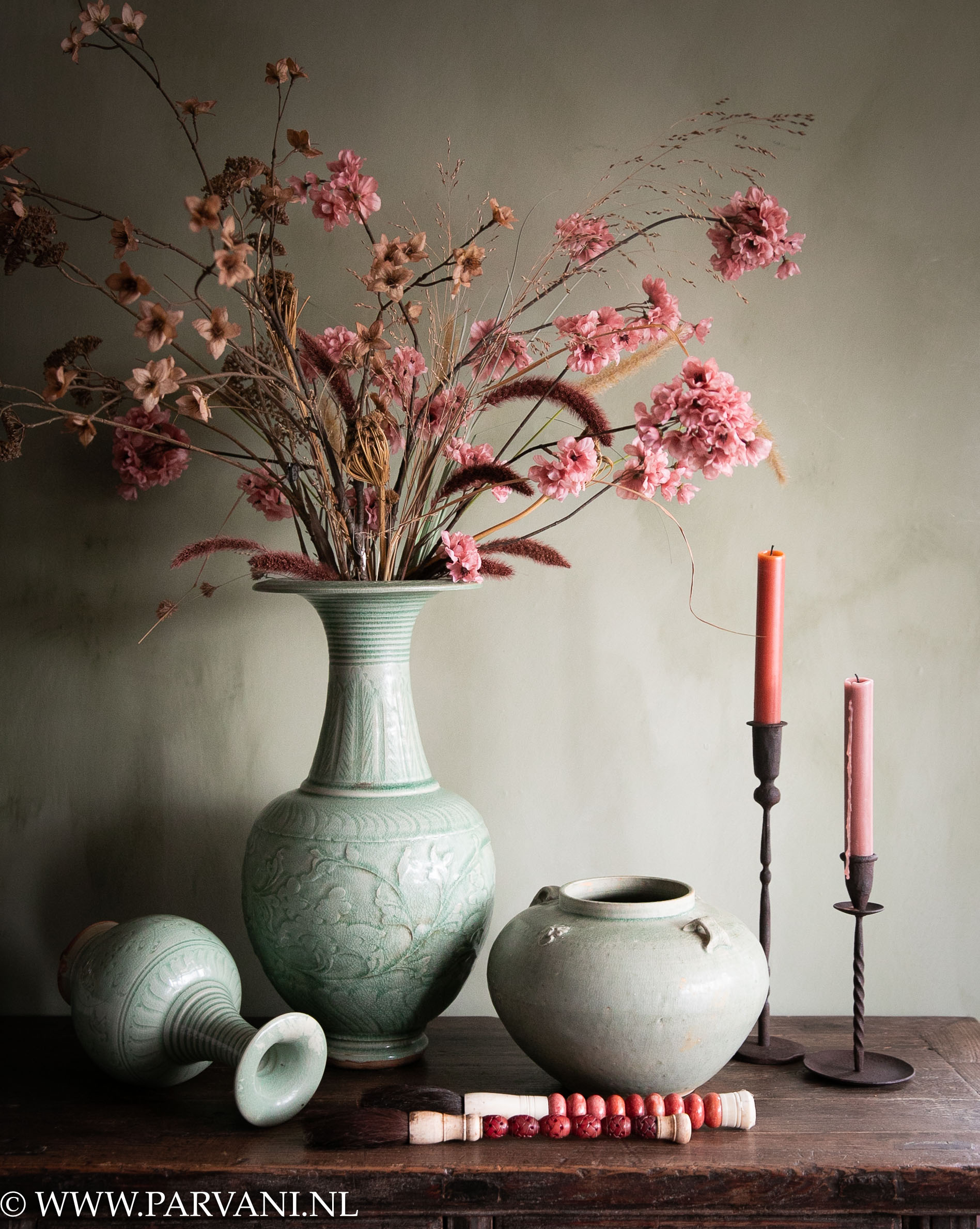 Chinese vazen in zachte jade groene kleur met roze zijden bloemen en kandelaars en rood roze kwasten
