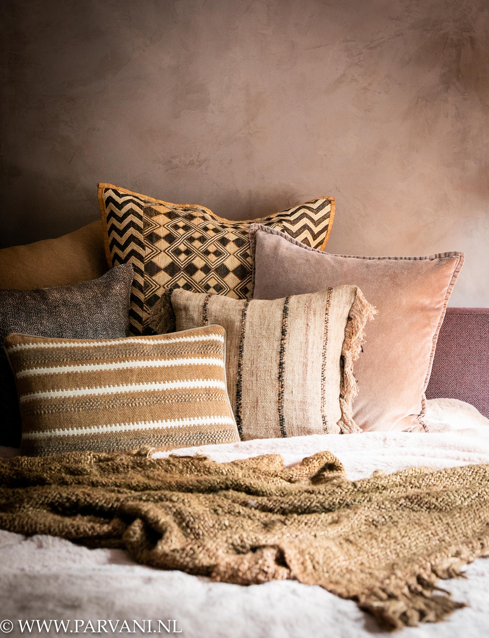 Rose Dust fresco kalkverf in slaapkamer met oudroze en bruine kussens bedsprei en plaid