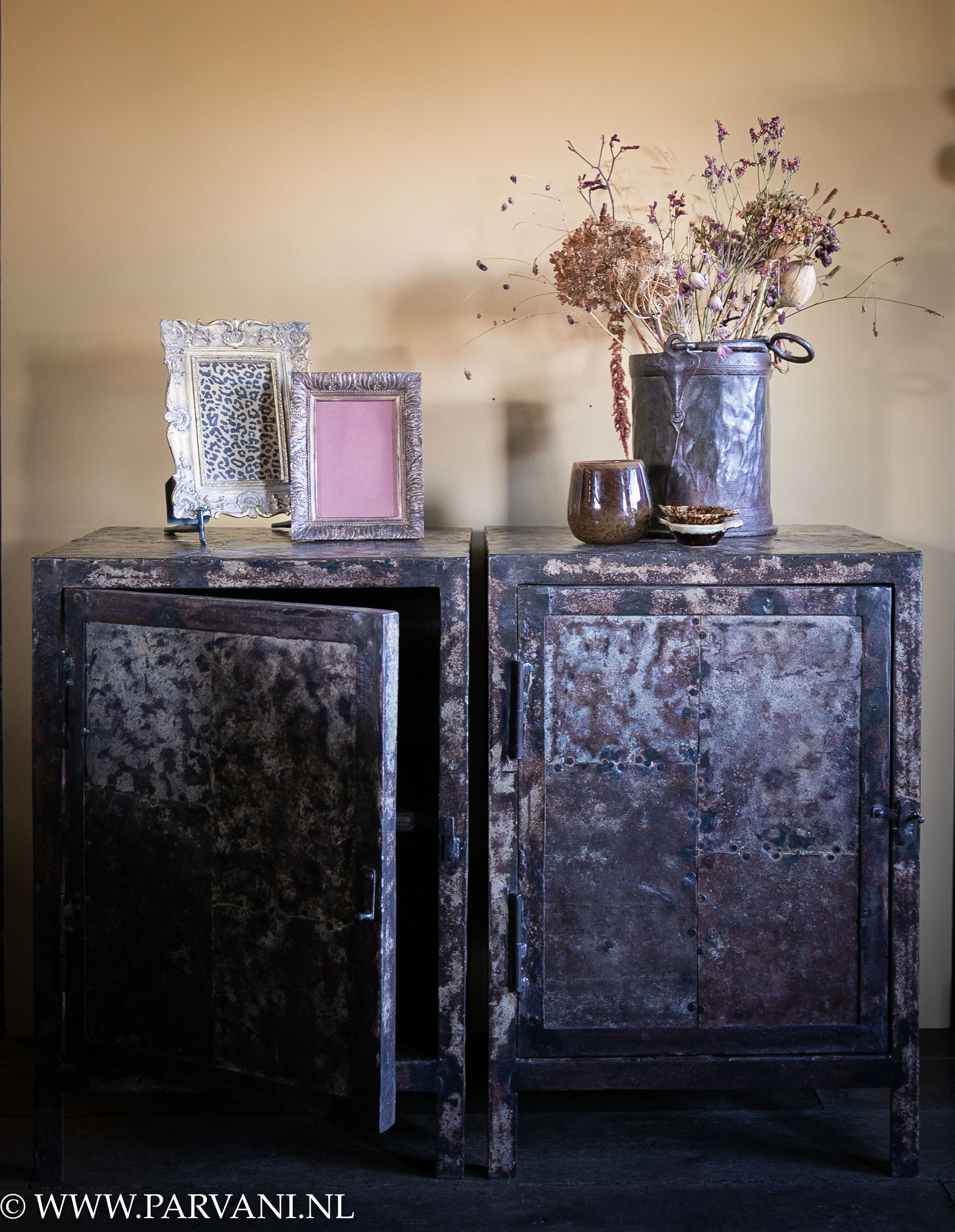 Set stoere vintage metalen nachtkastjes in donkerbruine kleur met ijzeren Indiase pot met bloemen
