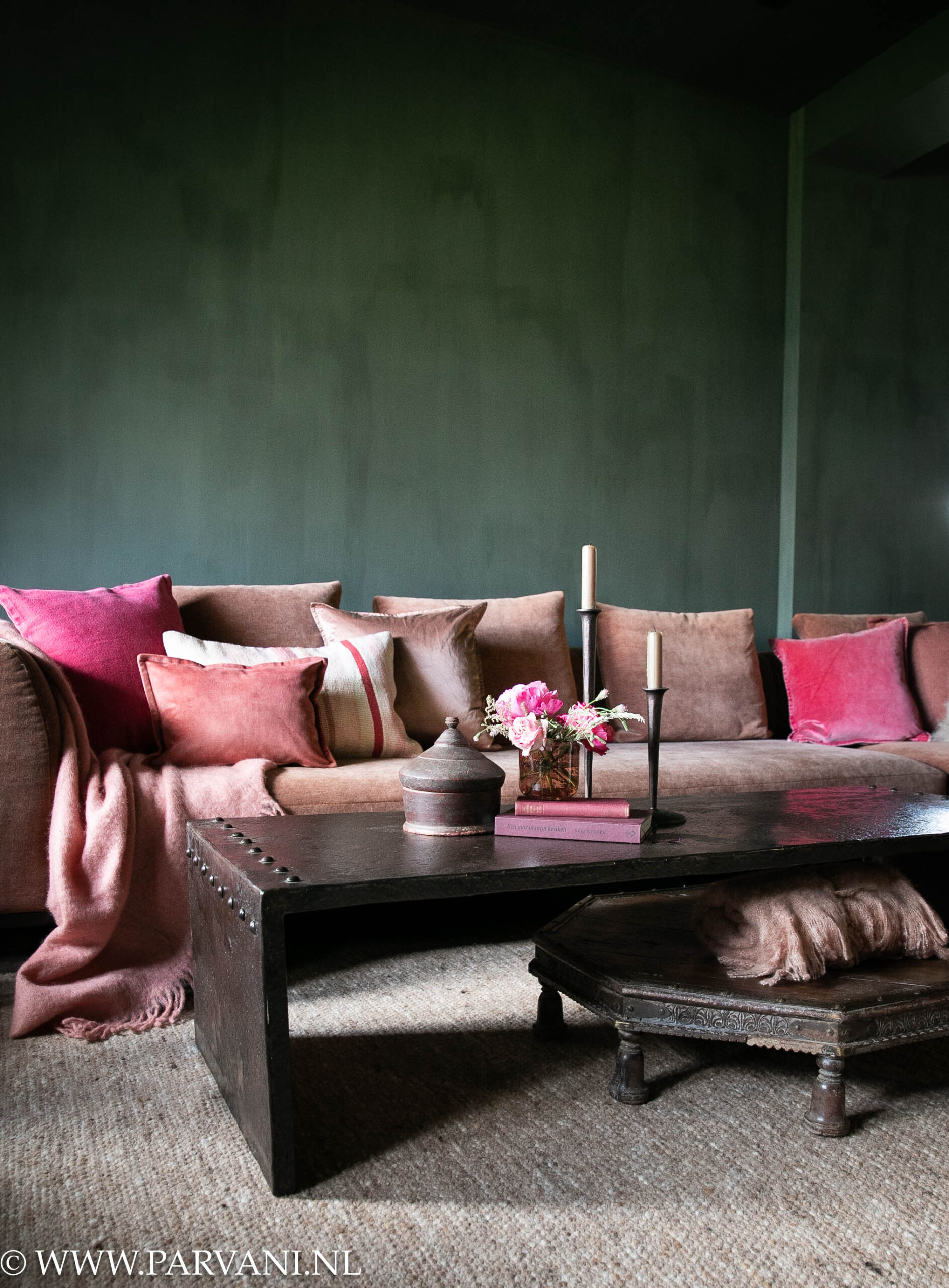 Stoere donkerbruine ijzeren salontafel met siernagels en unieke houten bajot tafel uit India in kleurrijke woonkamer