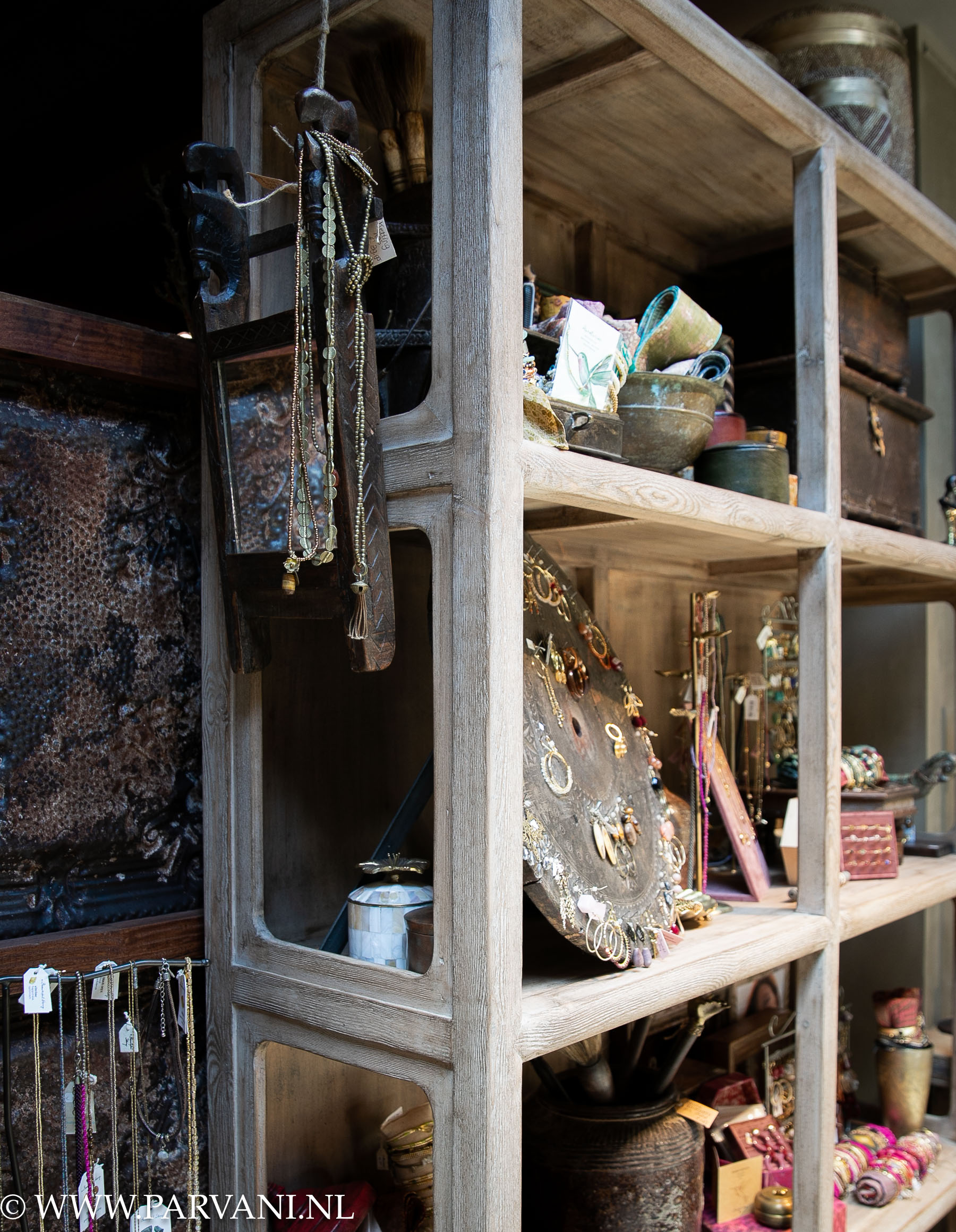 Unieke hoge open vakkenkast in naturel vergrijsd hout met woonaccessoires en sieraden