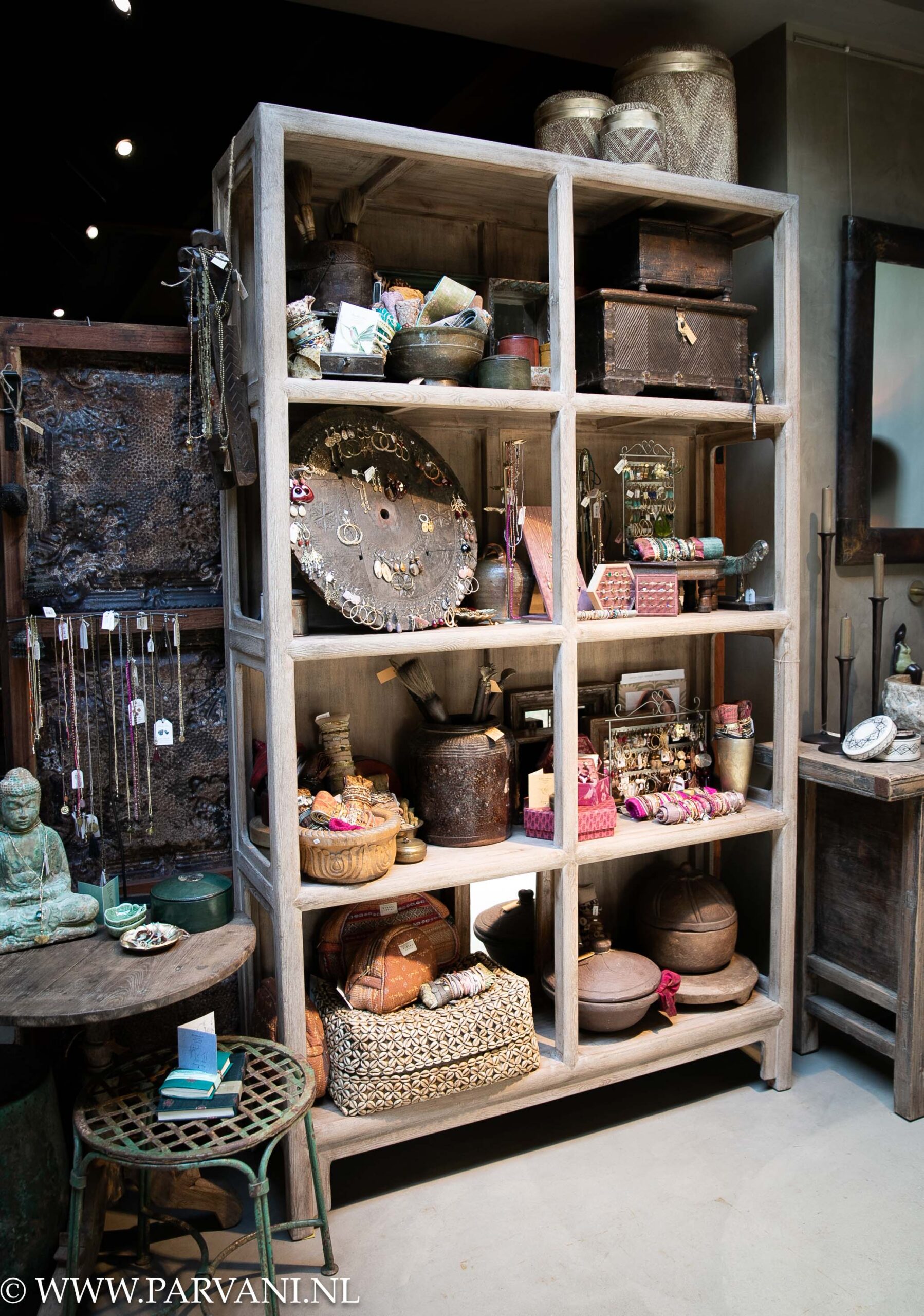 Unieke hoge open vakkenkast in naturel vergrijsd hout uit China met woonaccessoires en sieraden