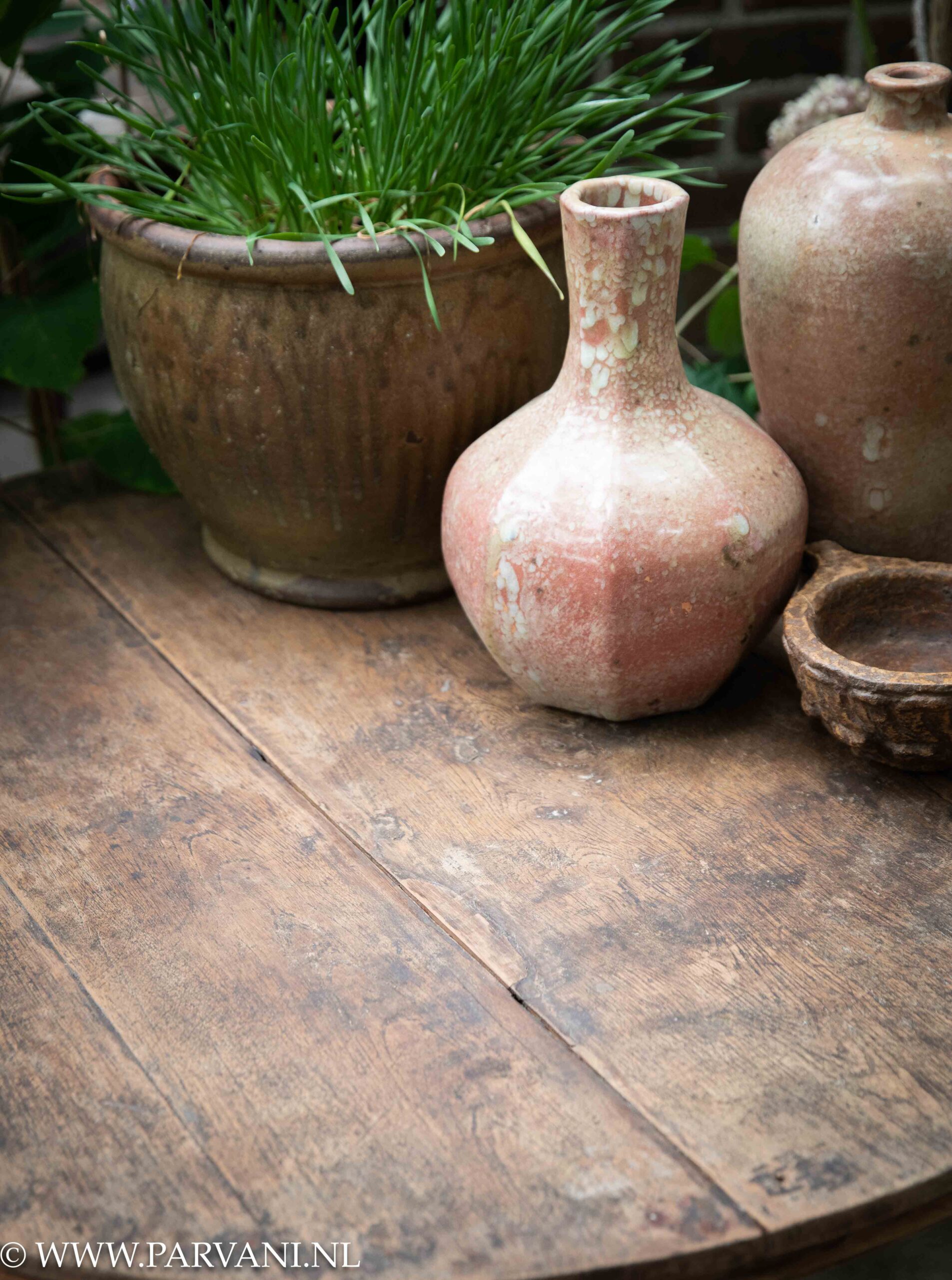 Grote oude houten wijntafel, hoge ronde bijzettafel uit Indonsië met mooie poot en oud roze Chinese vazen