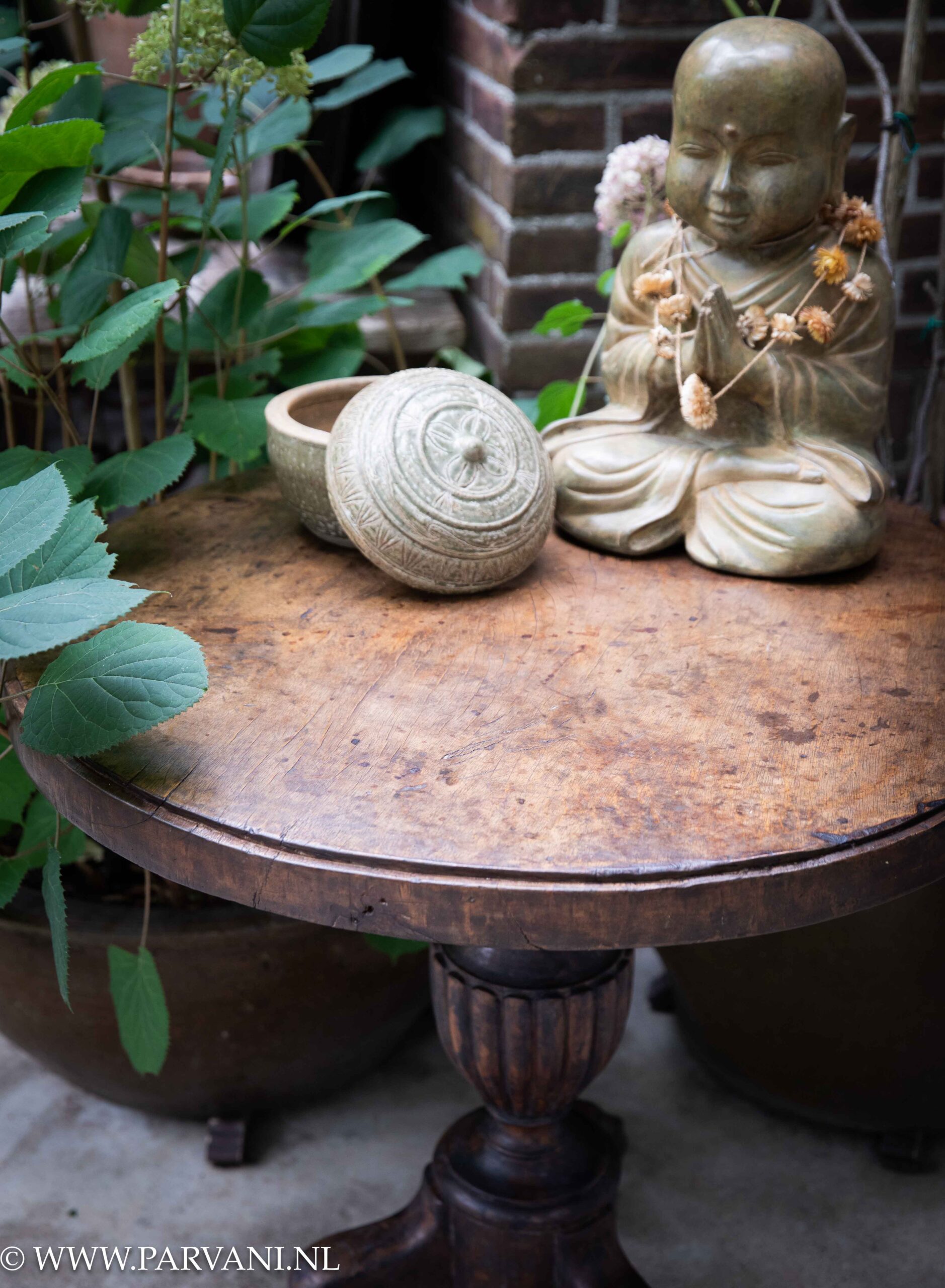 Oude ronde houten bijzettafel wijntafel uit Indonesië met mooie poot en donkerbruine kleur met bronzen buddha monnik
