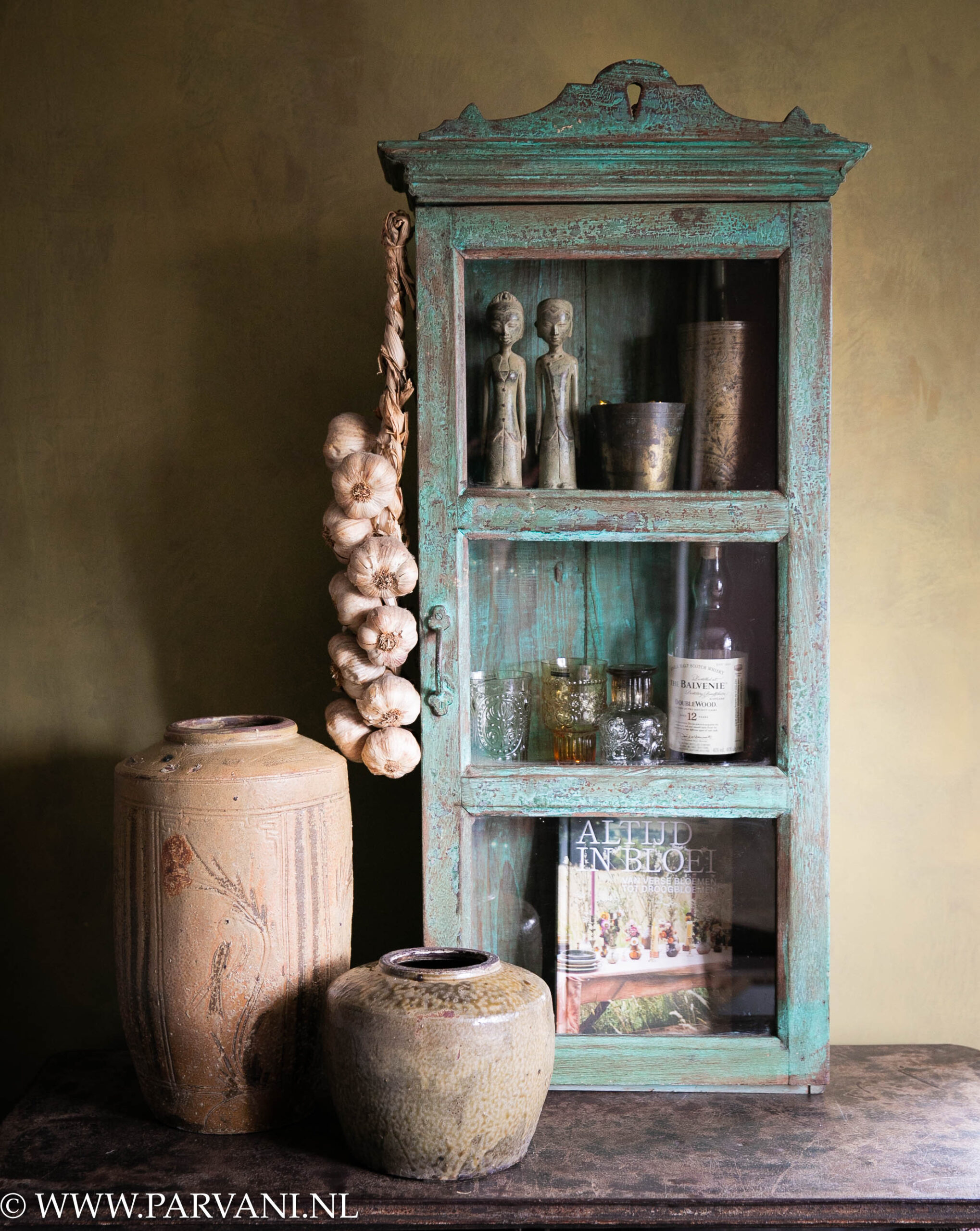 Turquoise groen glaskastje hangkastje uit India met mosterd geel groene aardewerk potten en bronzen echtpaar met messing bruidsbekers