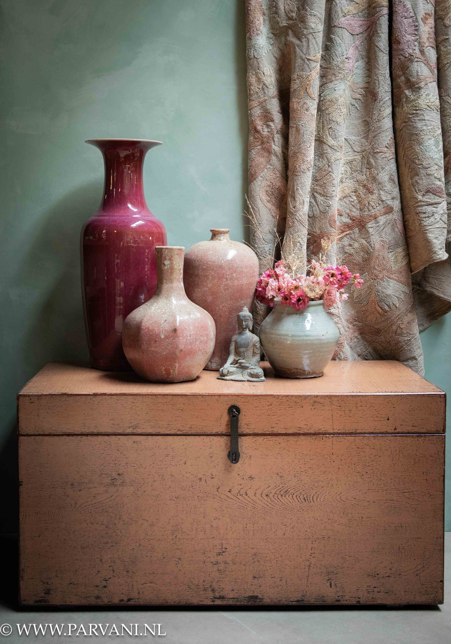 Zalm roze houten kist met kleurrijke Chinese roze en burgundy vazen, Suzani plaid en kleine bronzen buddha