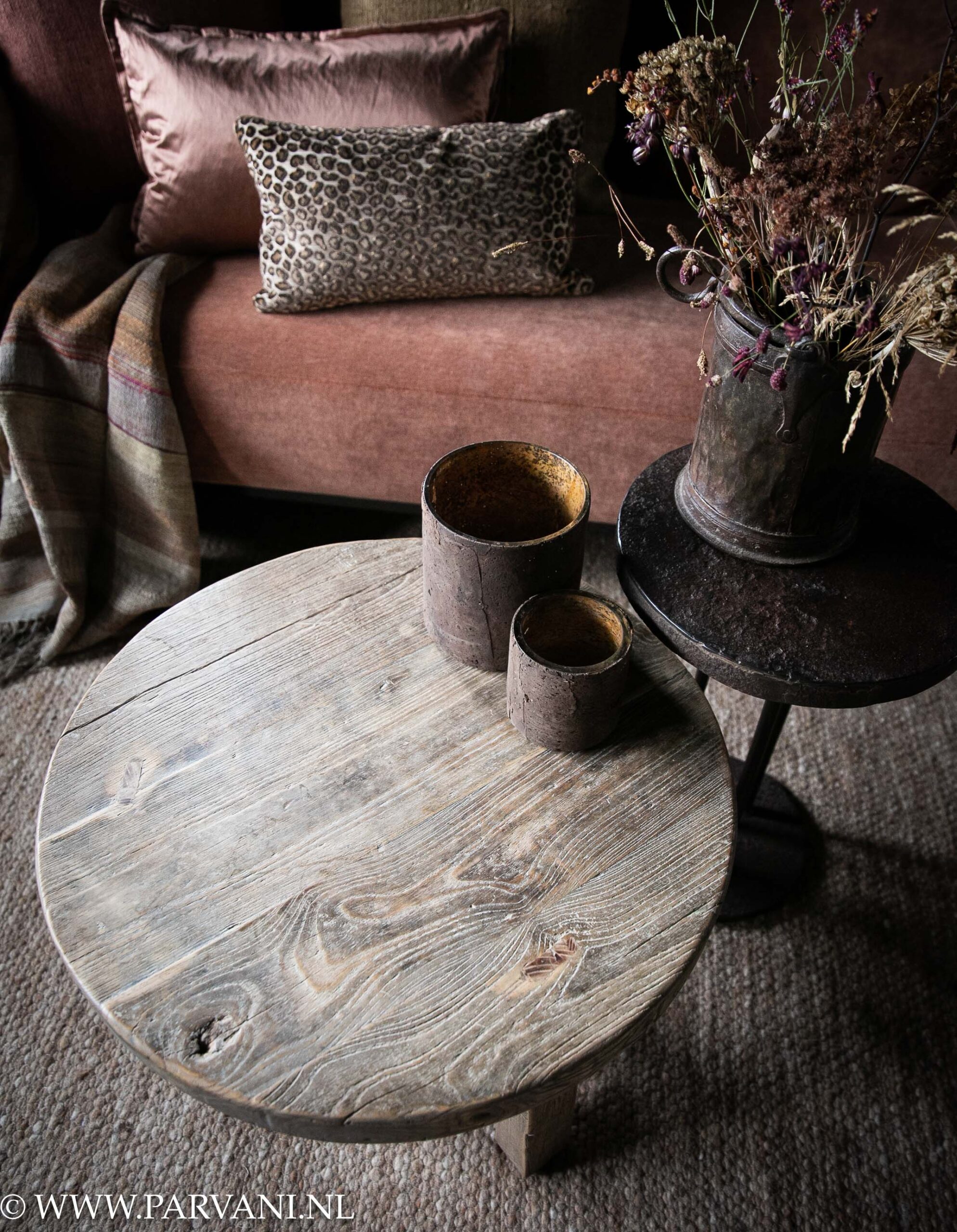 Ronde vergrijsd houten salontafel- bijzetter met klein bruin ijzeren bijzettafeltje bij bank